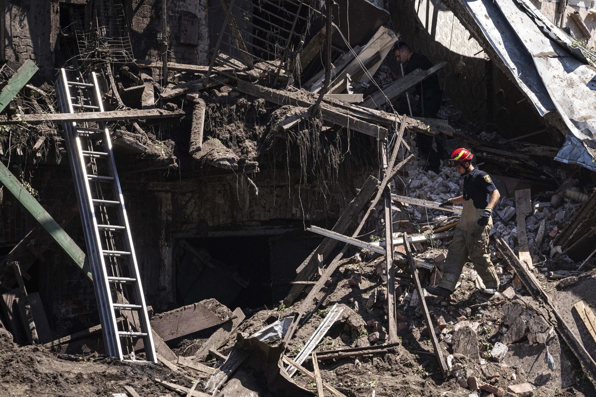 Rescue worker and police officer inspect a site of destroyed house after a Russian attack in a residential neighbourhood in downtown Kharkiv