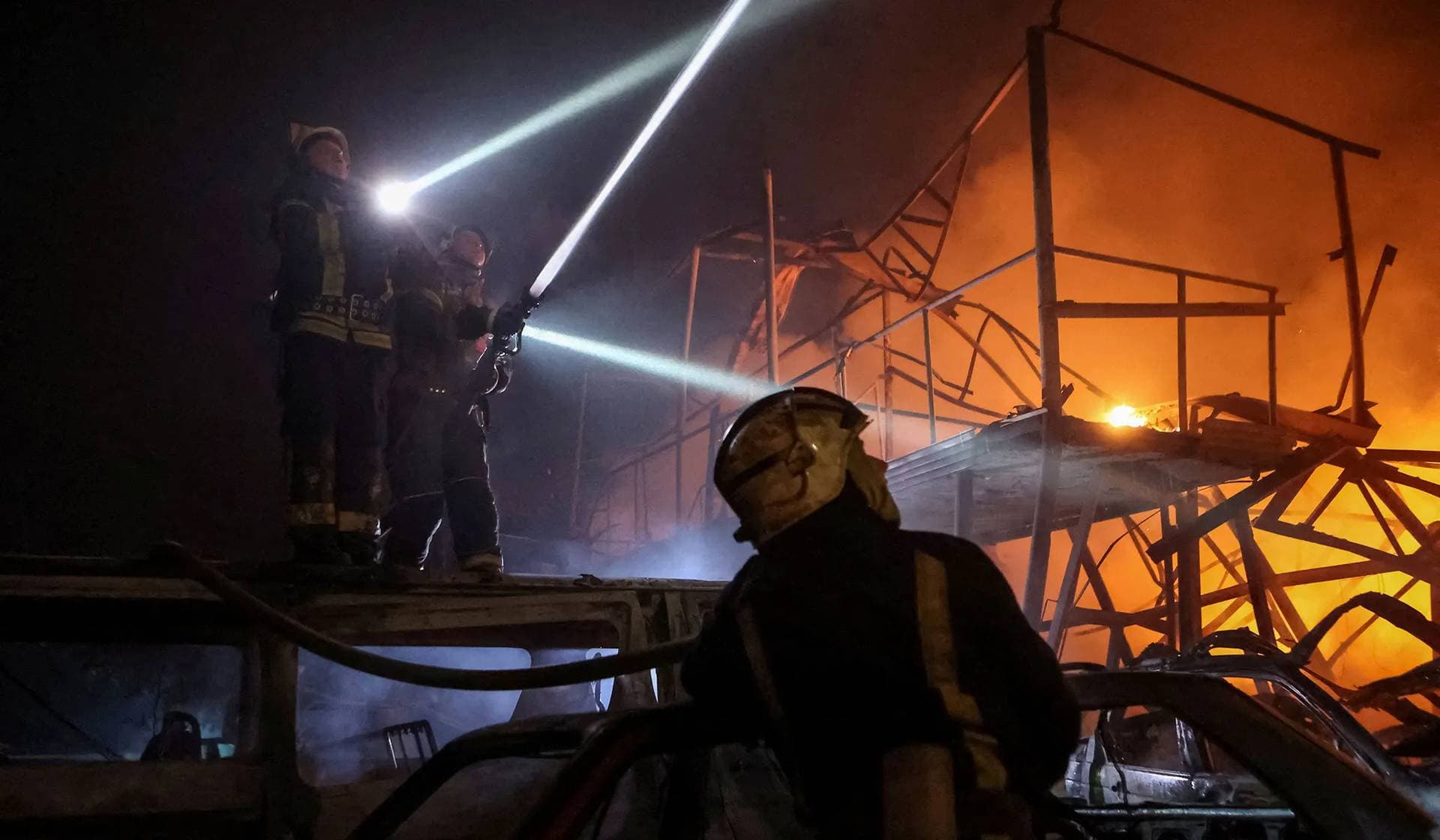 Emergency personnel work at a site of a Russian drone strike in Kharkiv