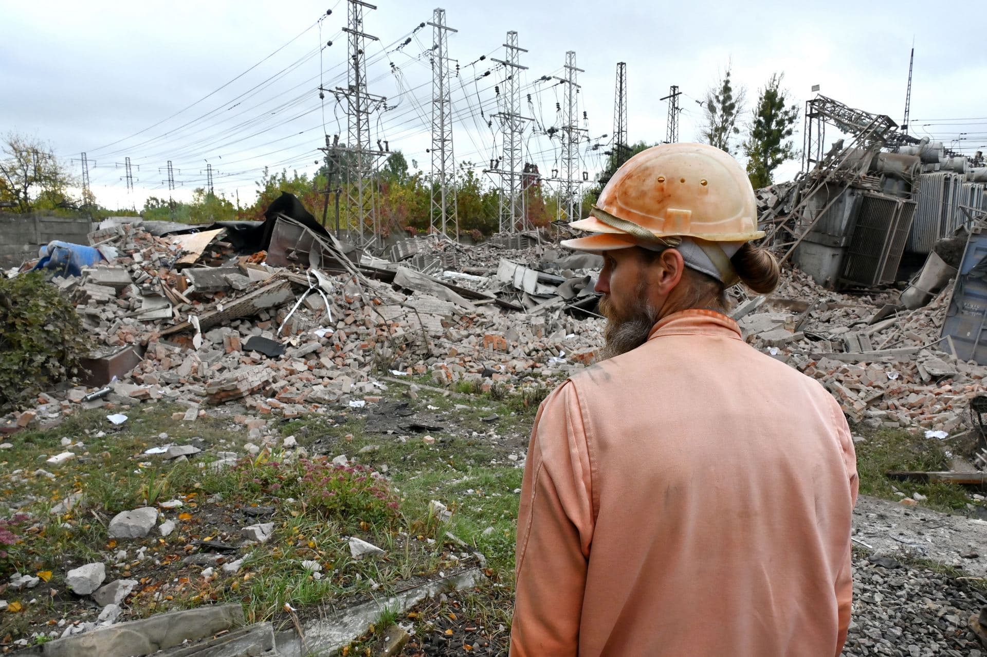 An employee of an energy company inspects an electrical transformer substation destroyed by Russian missile strikes on the outskirts of Kharkiv