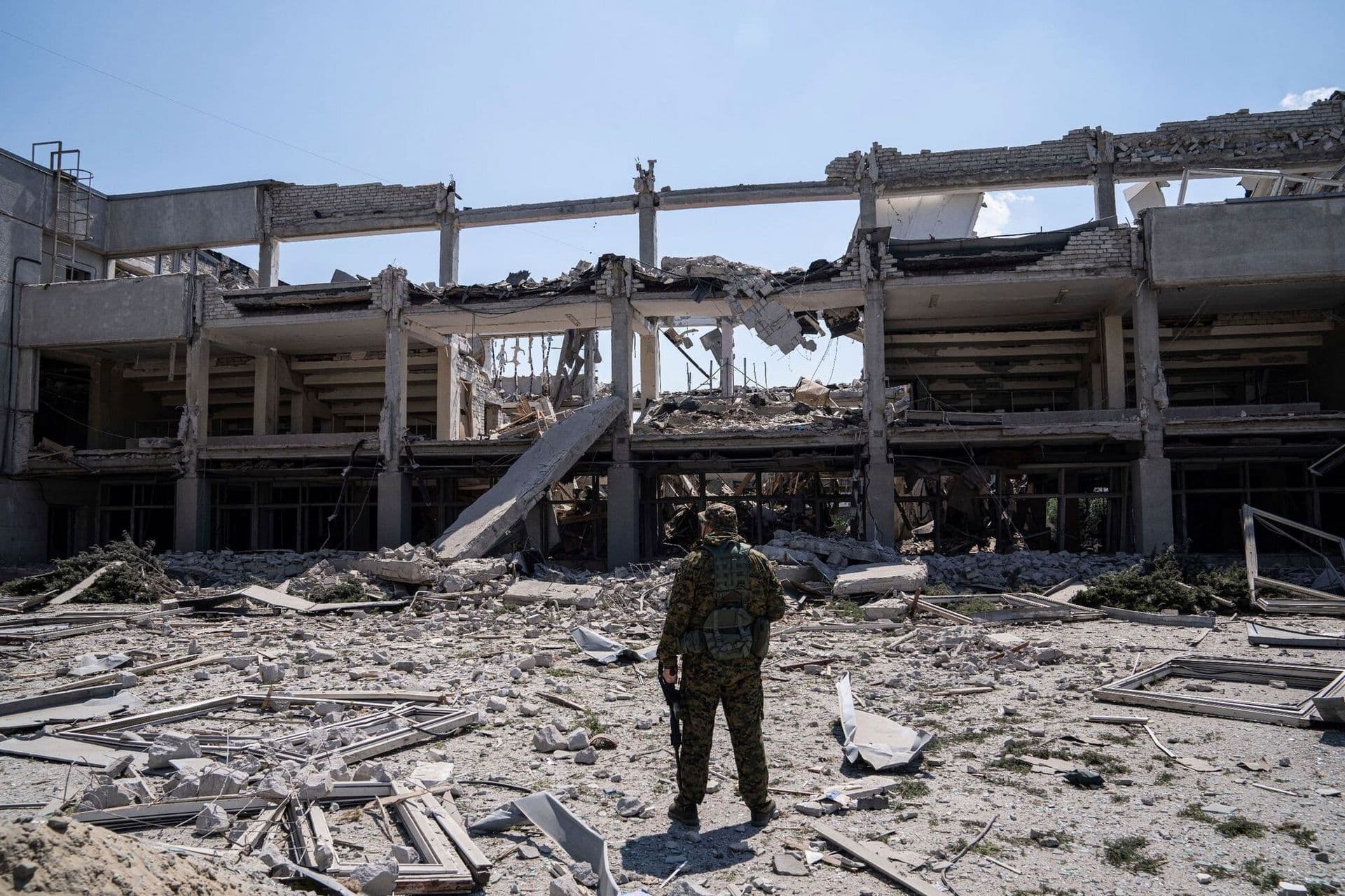 Ukrainian serviceman looks on National Pedagogic university destroyed by a Russian attack in Kharkiv