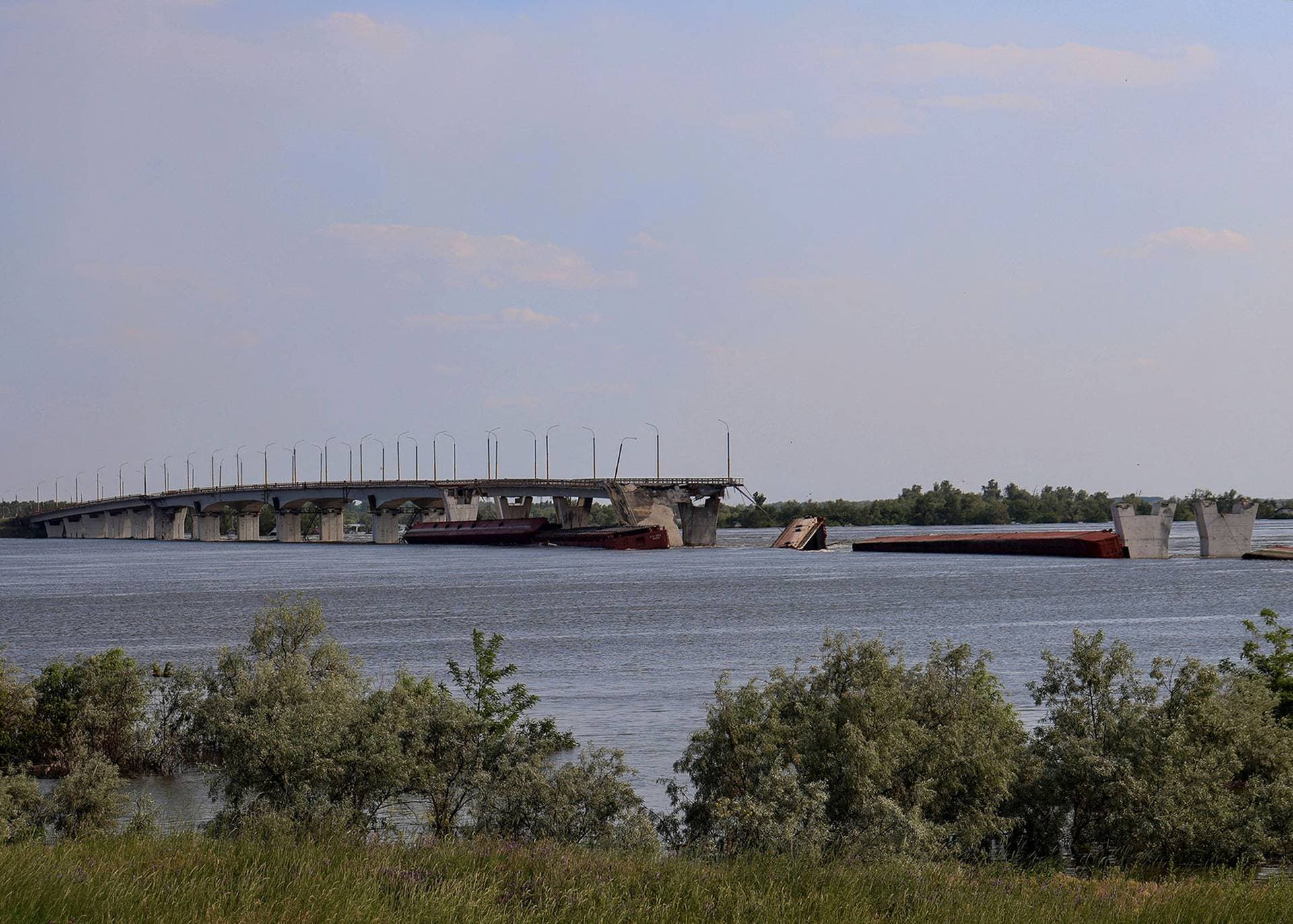 The destroyed Antonivskyi bridge is seen over the flooded Dnipro river