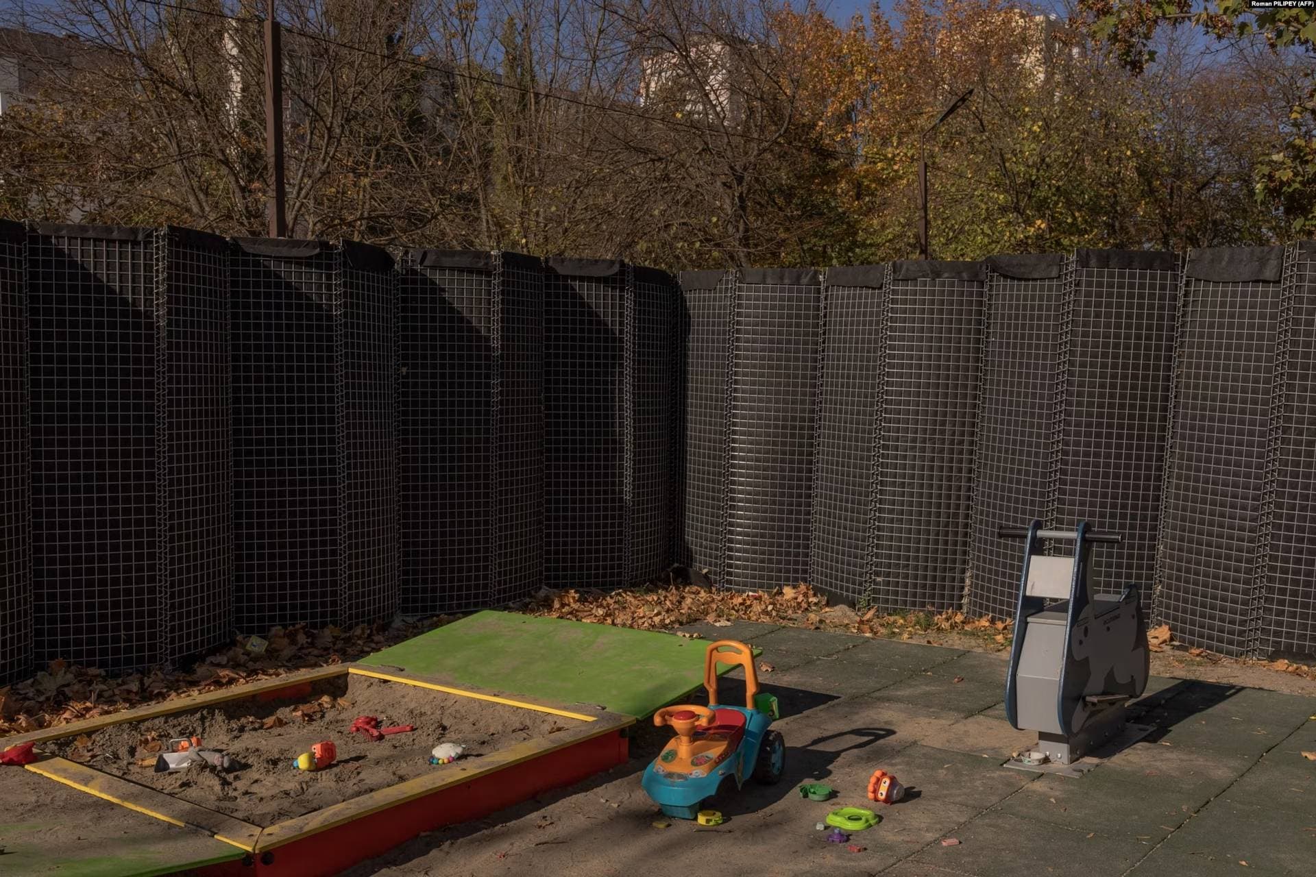 A protective fence against shelling encircles a children's playground in the southern city of Kherson