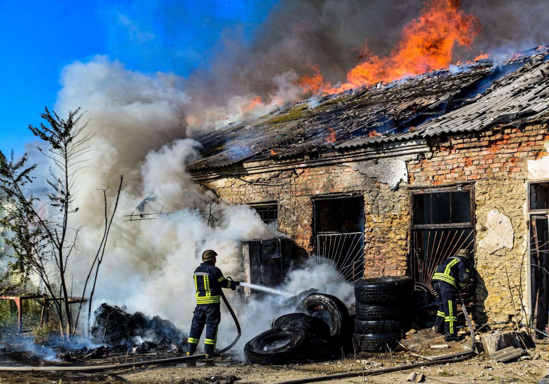 Firefighters work to extinguish a fire in a warehouse after shelling in Kherson