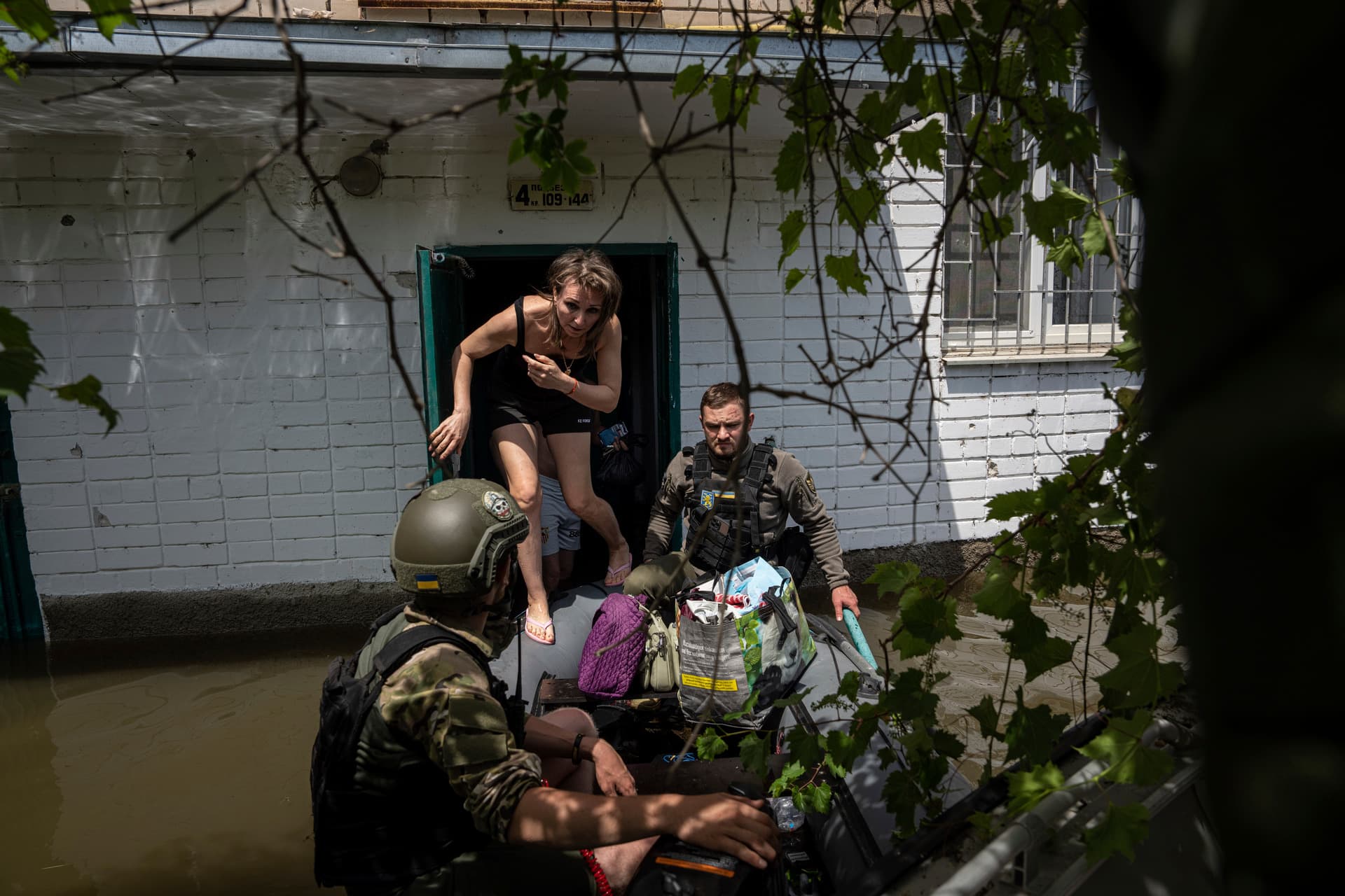Local resident gets on a small boat as she is evacuated by Ukrainian servicemen from a flooded neighborhood in Kherson