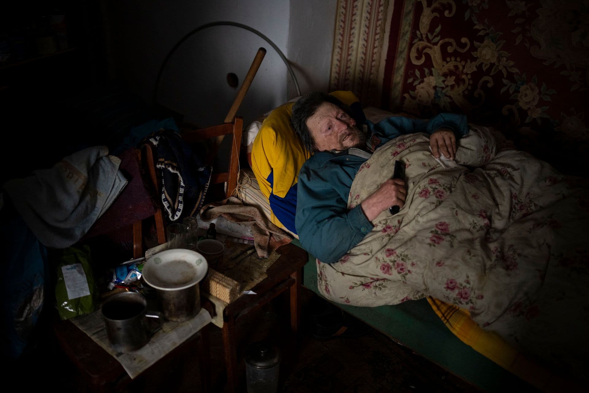 Suffering from cancer, Gennadiy Shaposhnikov, 83, rests in his partially destroyed home which was hit by Russian shelling last fall in Kalynivske