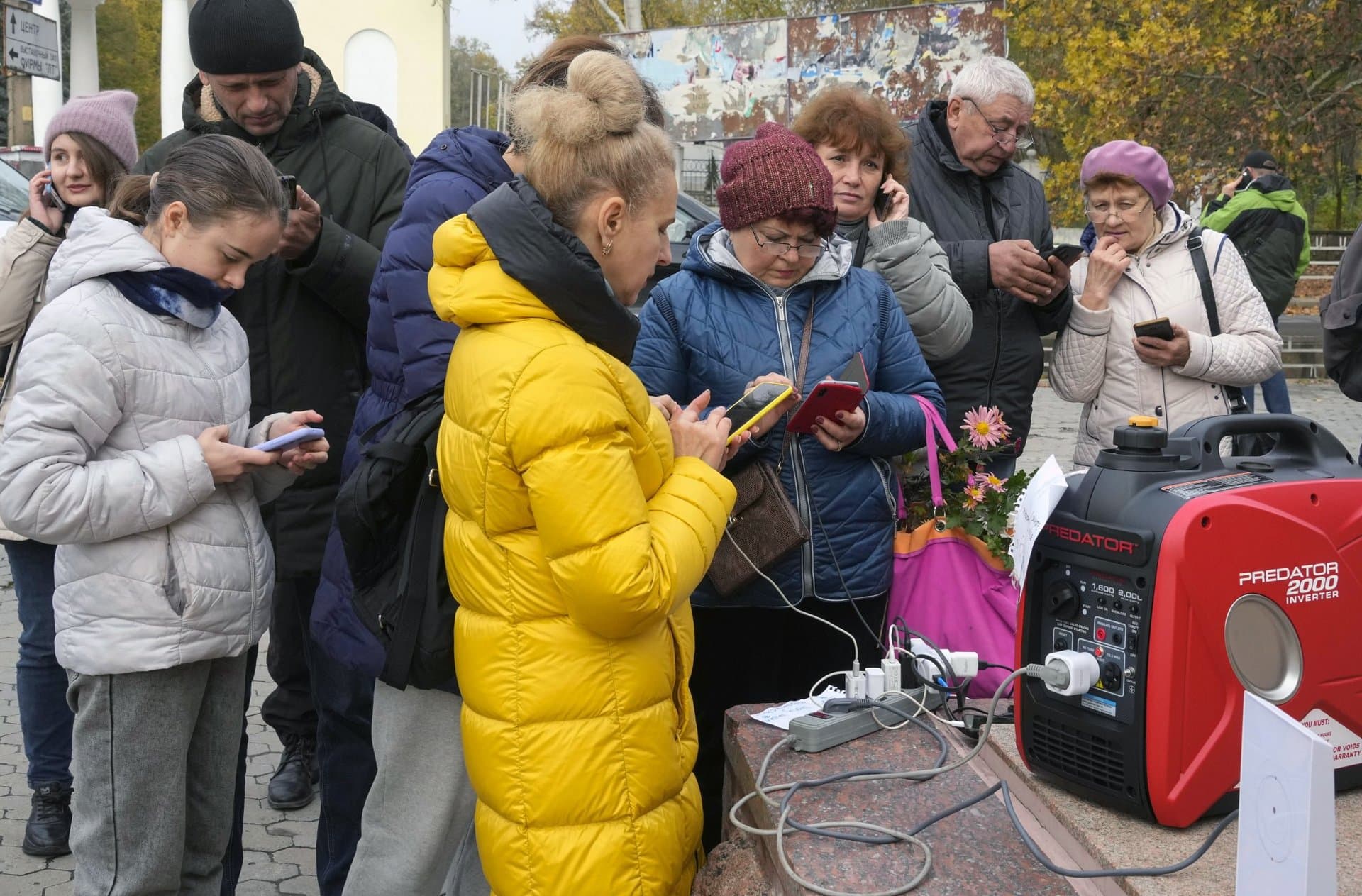 People charge their phones, try to connect to the internet and make phone calls on central square in Kherson