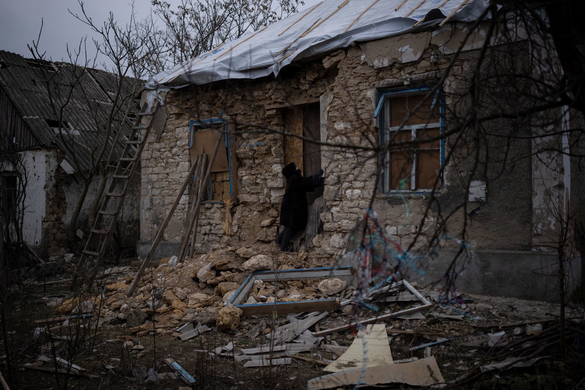 Oleksandra Hryhoryna inspects her house which was damaged by shelling last fall in Kalynivske