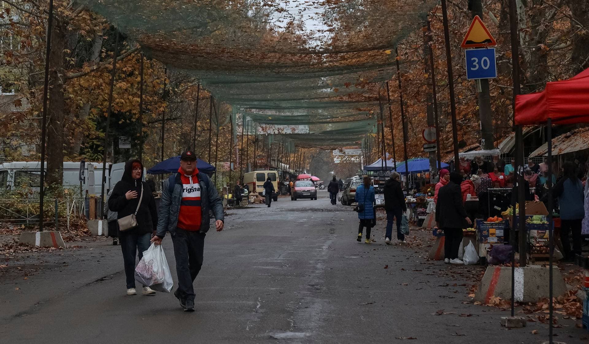 Residents visit a street market covered with an anti-drone net in the frontline city of Kherson