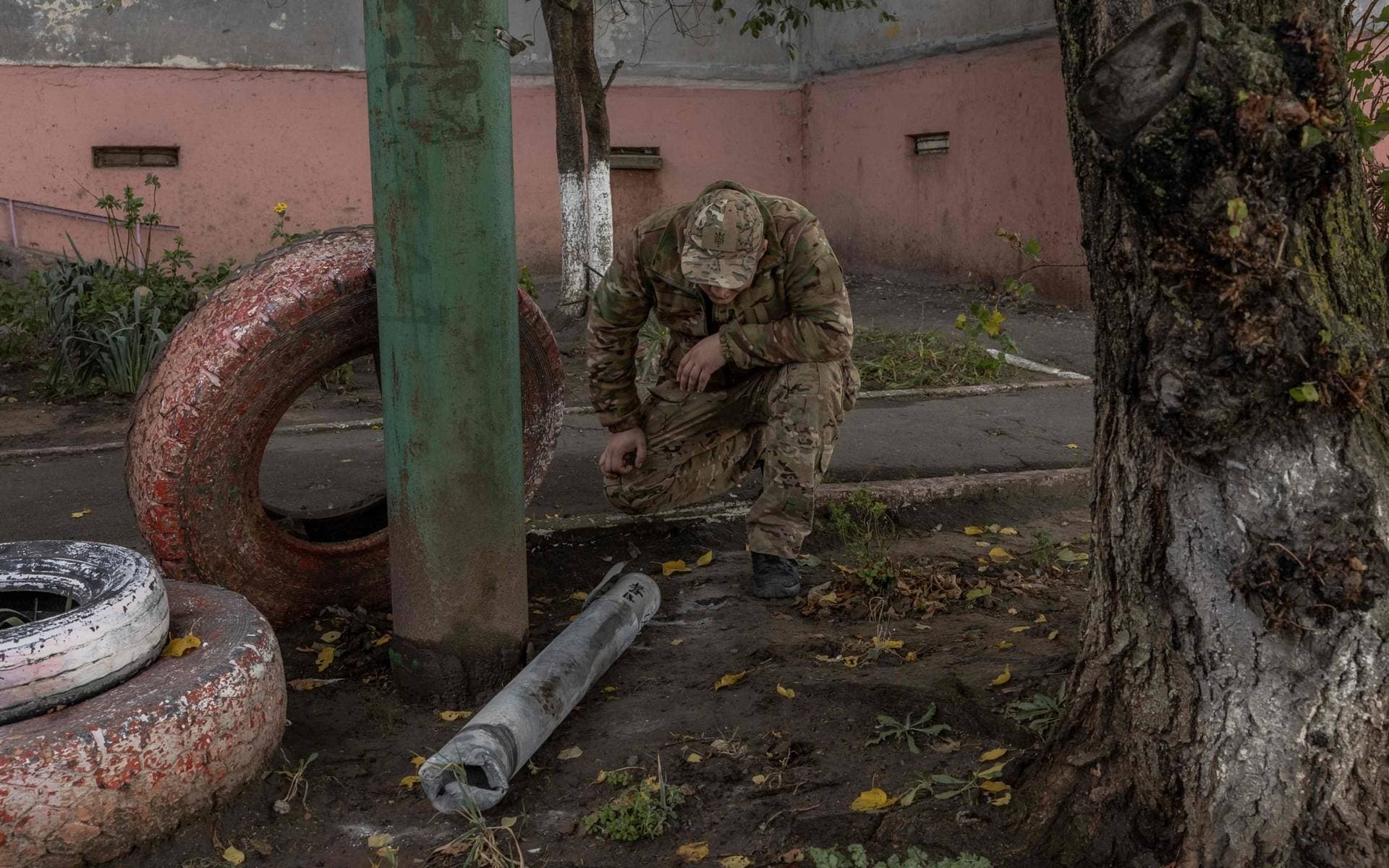 A man inspects part of a missile that fell during an overnight Russian attack in Kherson