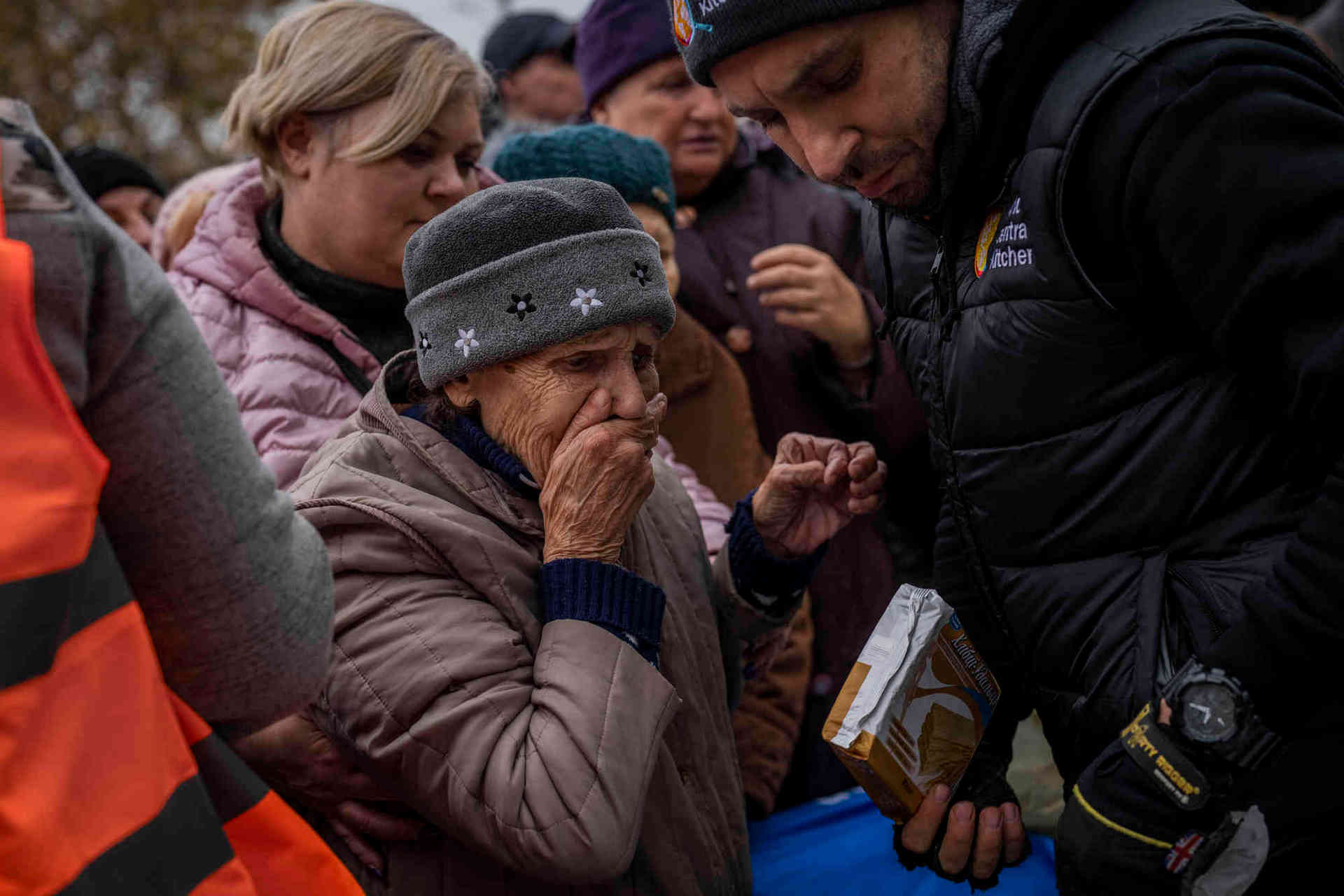 A woman reacts after receiving food donations from World Central Kitchen in Kherson