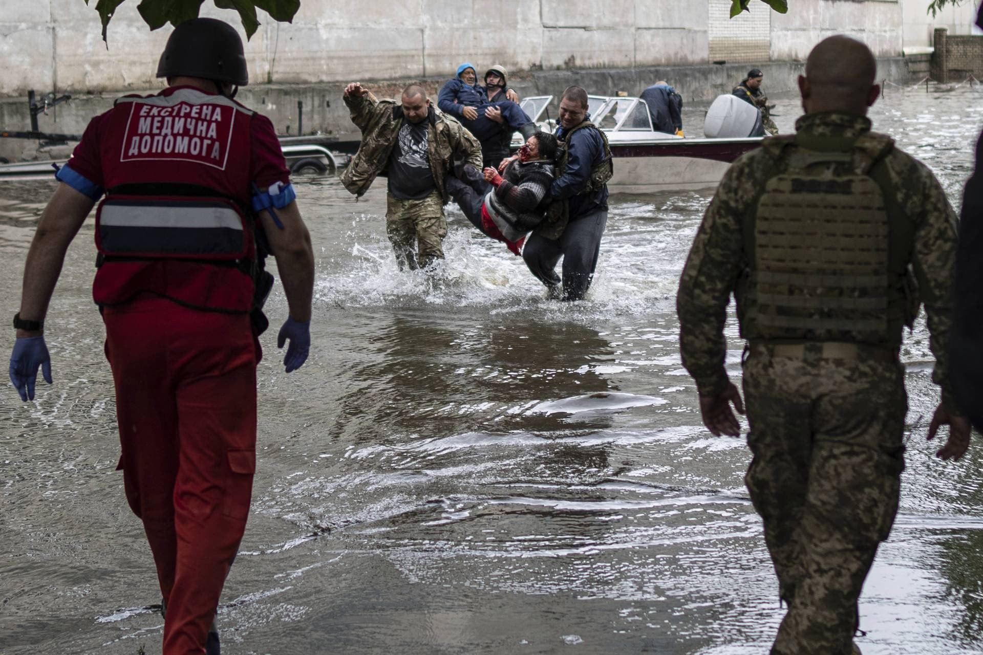 Emergency teams help rush to safety injured civilian evacuees on the western bank in Kherson