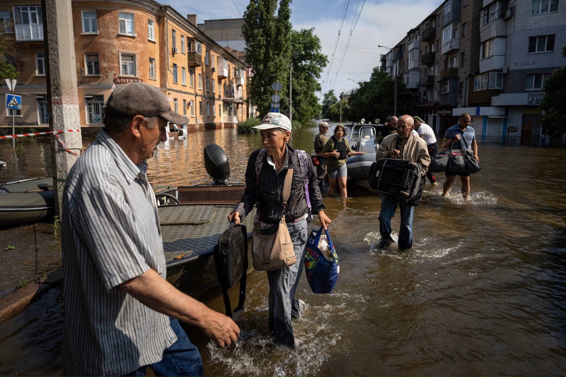 Alyona Shkrygalova carries her bags after evacuating from a flooded neighborhood on the left bank of the Dnipro river in Kherson