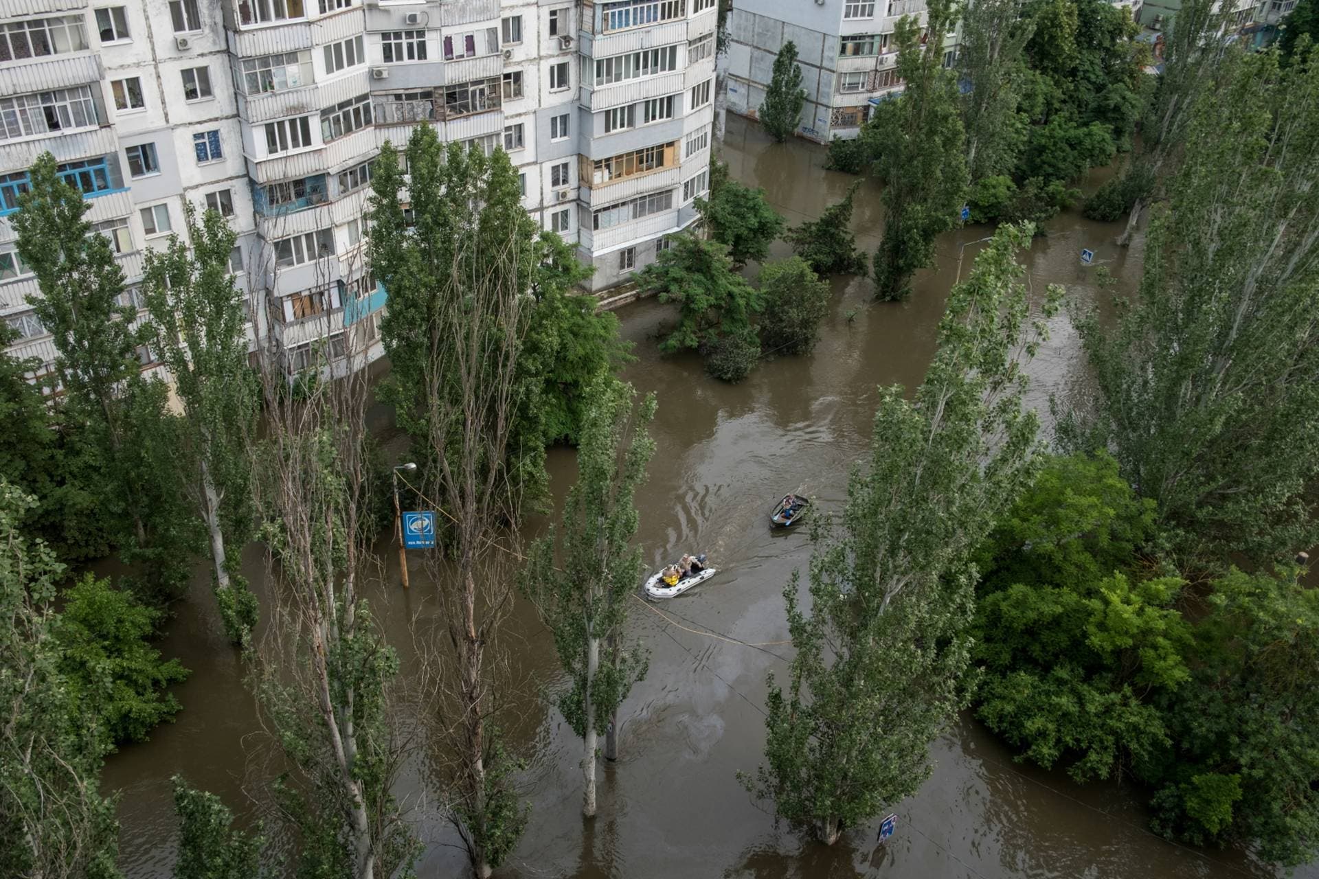 A general view shows residents using rubber boats as they evacuate from a flooded area of Kherson
