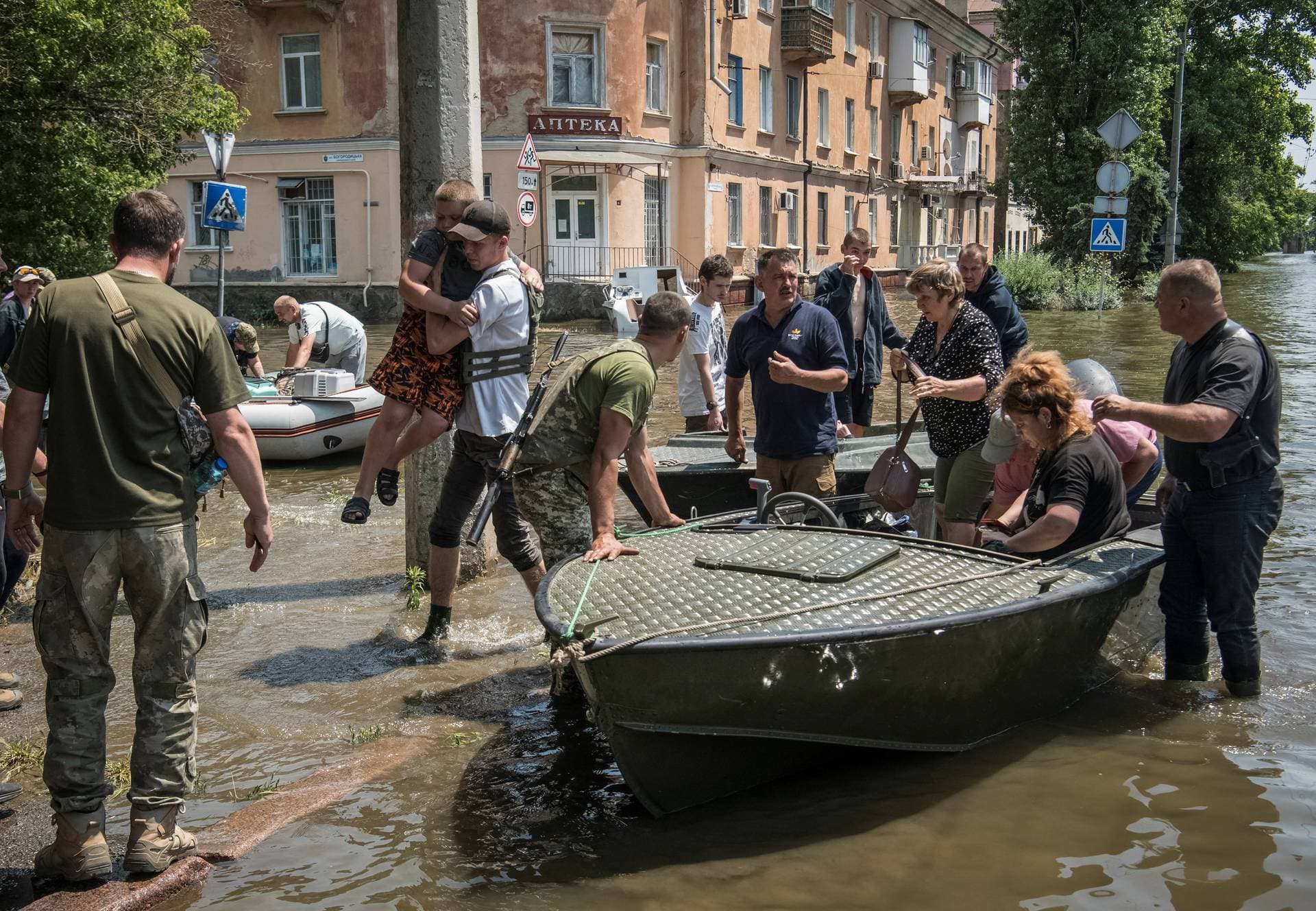 Rescuers, servicemen and volunteers evacuate local residents from a flooded area in  Kherson