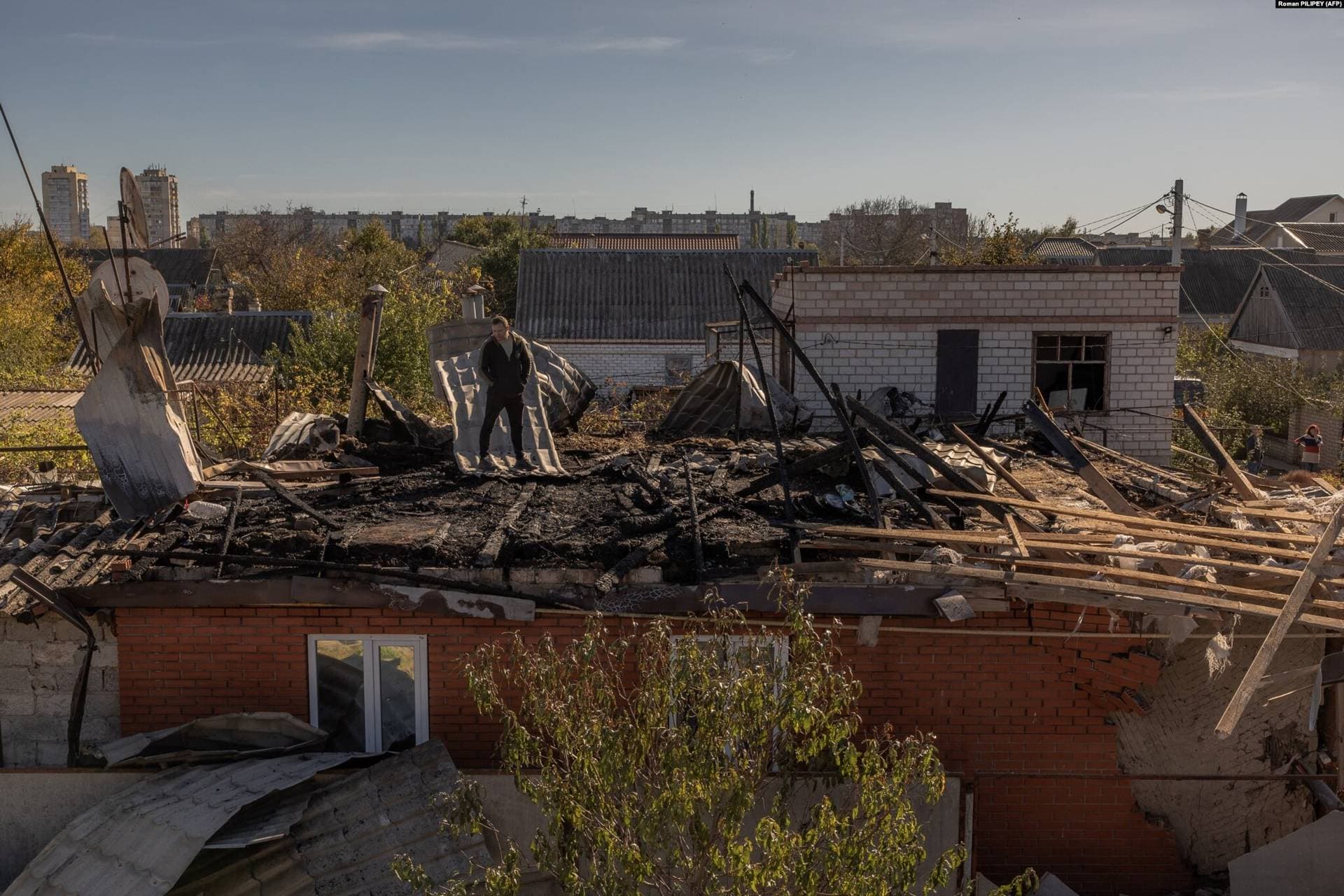 A man surveys the damage to a house from an overnight attack in Kherson