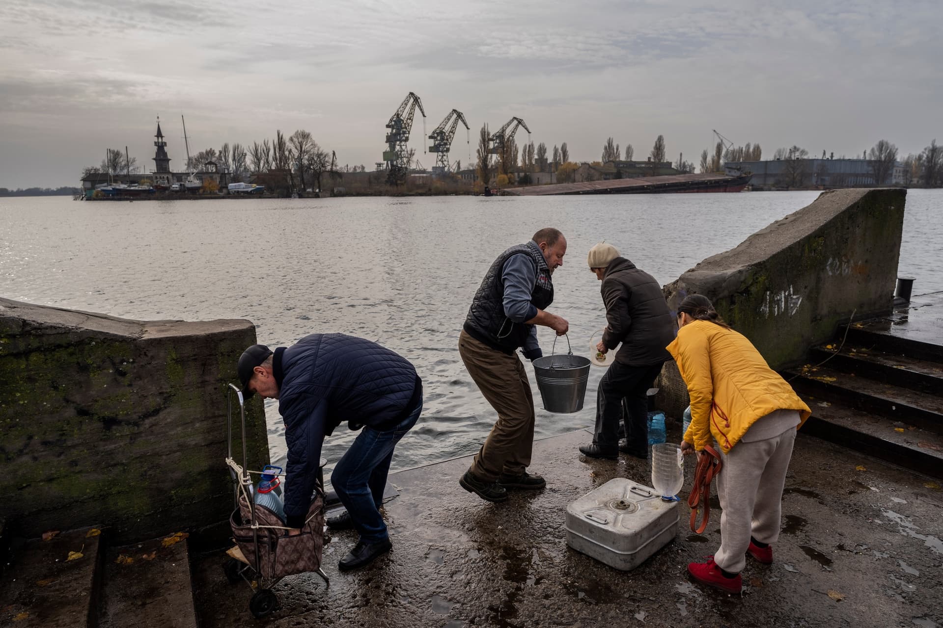 Residents of the recently liberated city of Kherson collect water from the Dnipro river bank