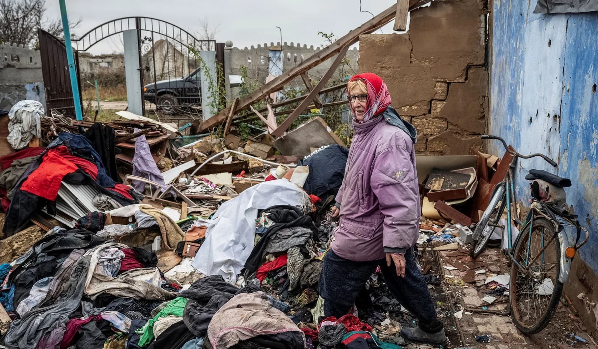 Local resident Lidiia looks for her things in her destroyed house in the village of Pokrovskii Posad
