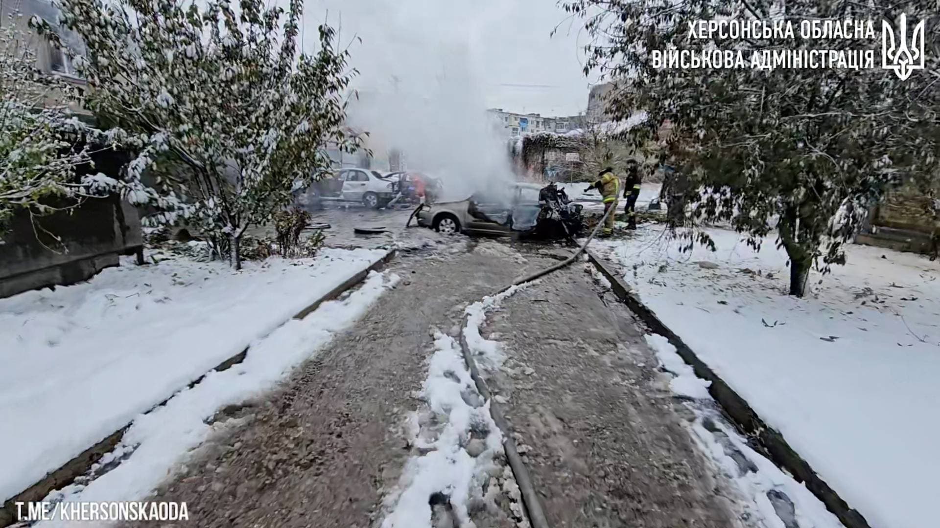 First responders work near burnt-out cars after a reported deadly Russian artillery strike in Kherson