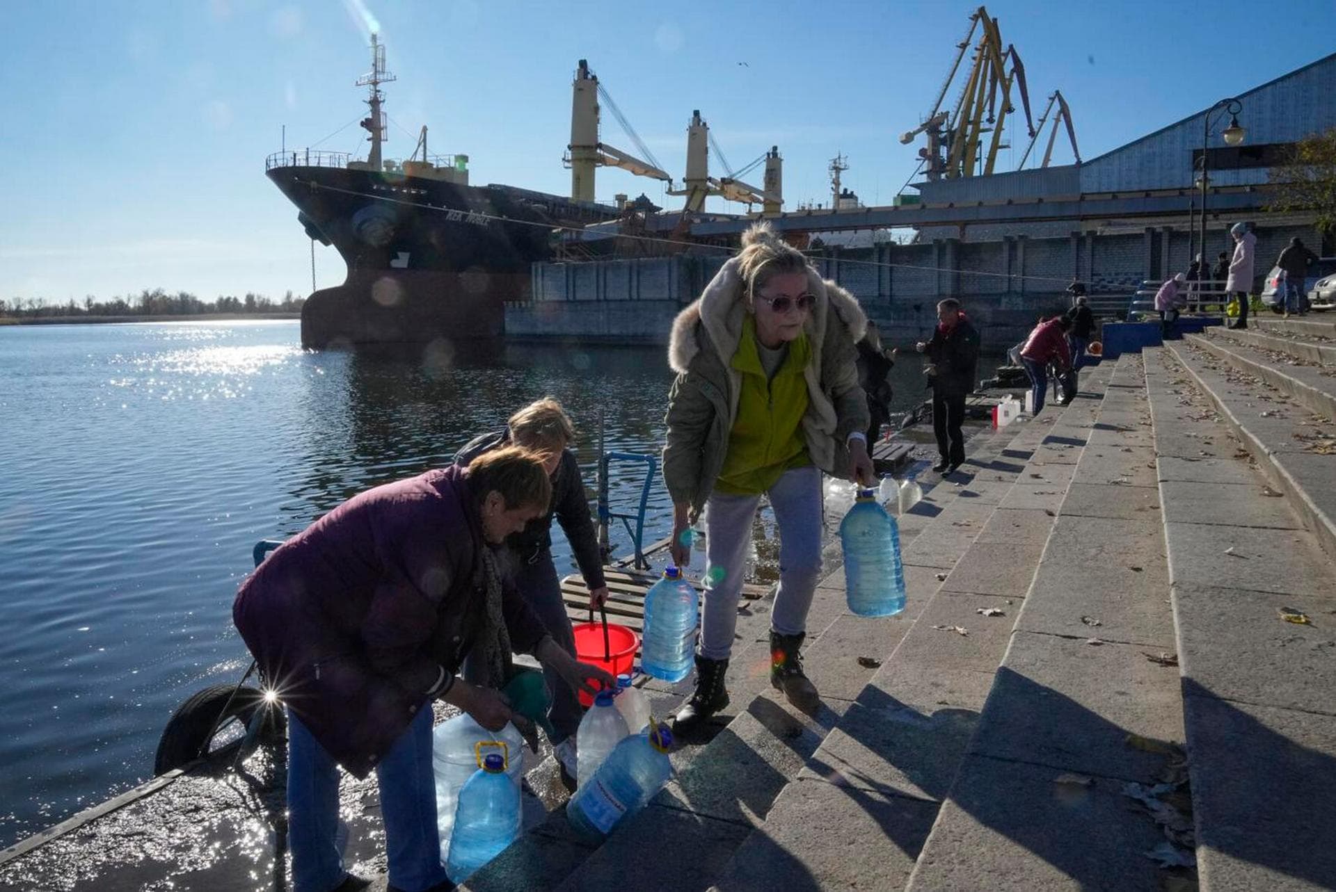 People collect water from a Dnipro river in Kherson