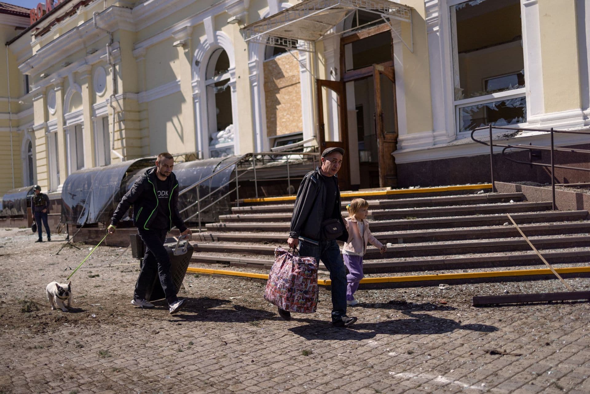 People run for cover near the train station in Kherson during an early morning Russian strike