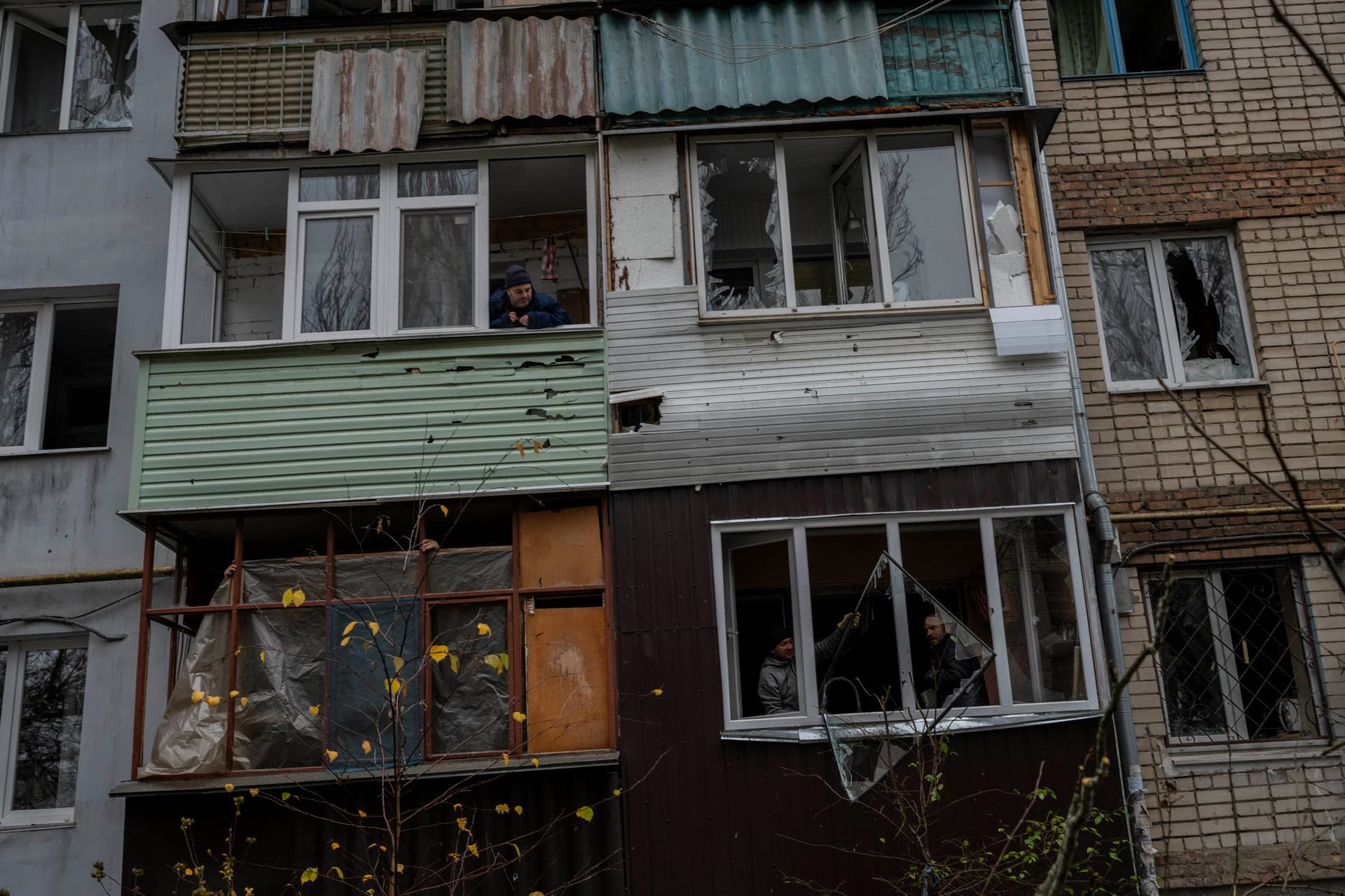 Residents remove debris from a damaged building the day after a Russian attack in Kherson