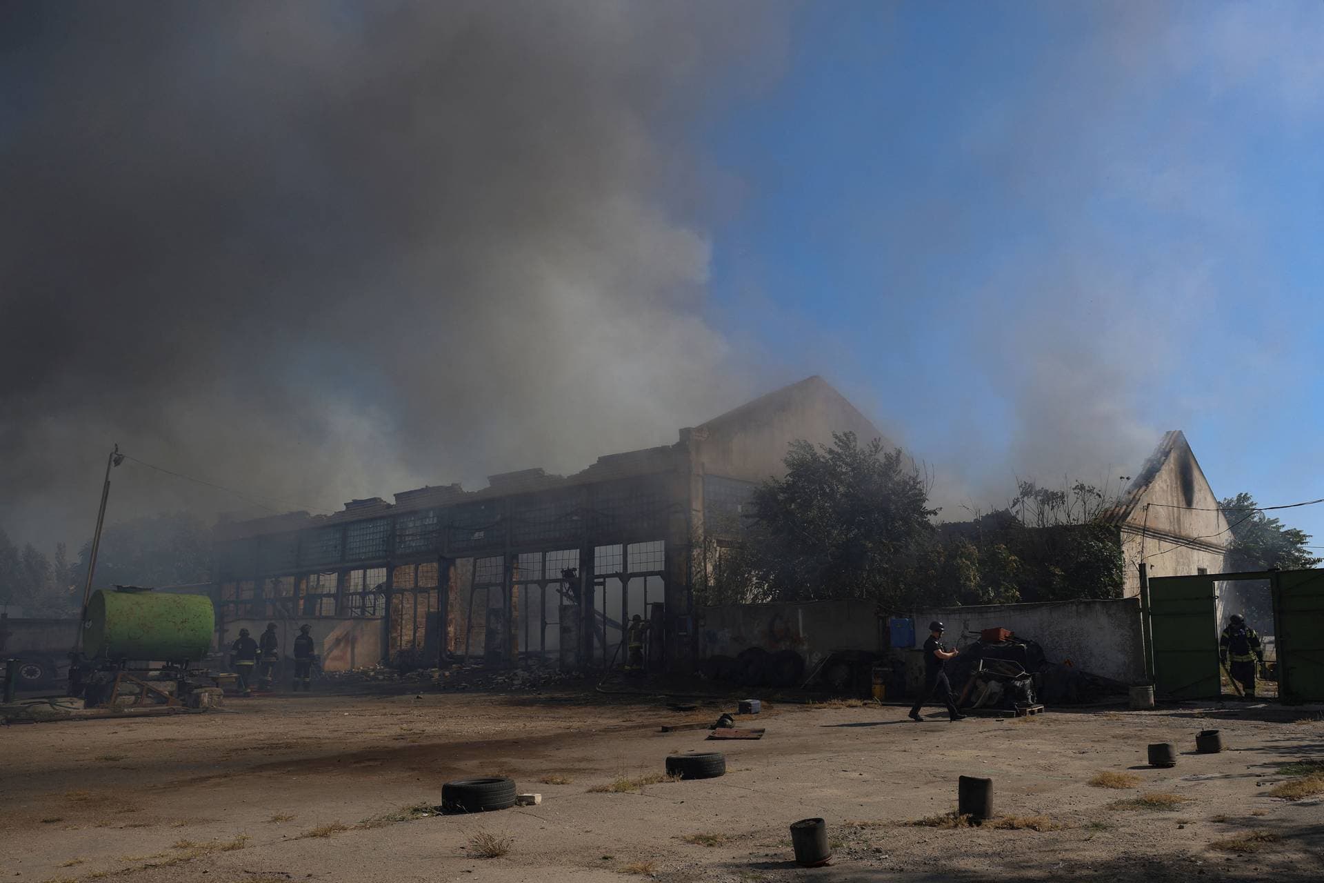 Police officers and firefighters work at a site of warehouses damaged during a Russian military strike in Kherson