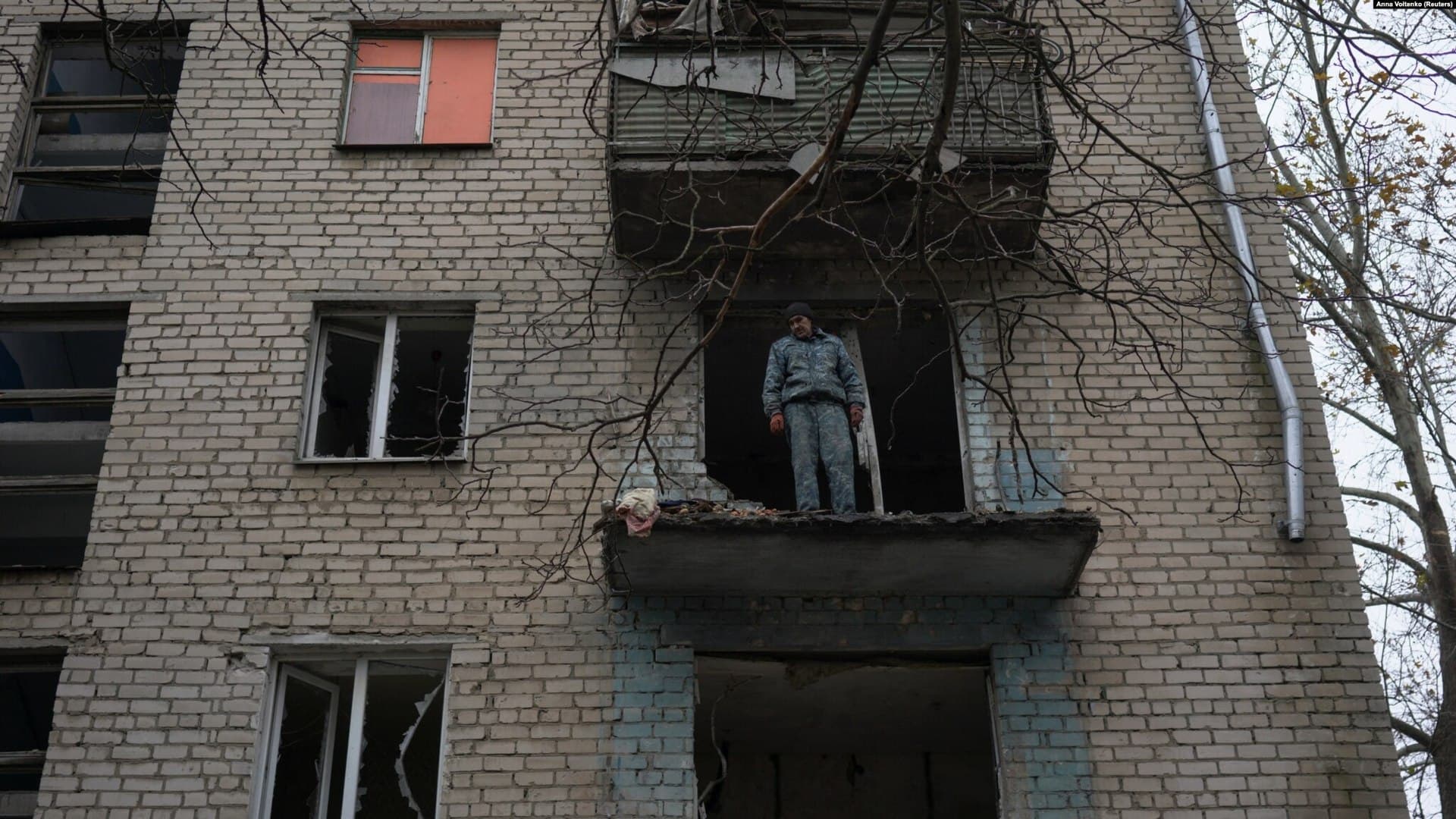 Oleksandr Antonenko looks down on destruction from damaged apartment of residential building in Kherson