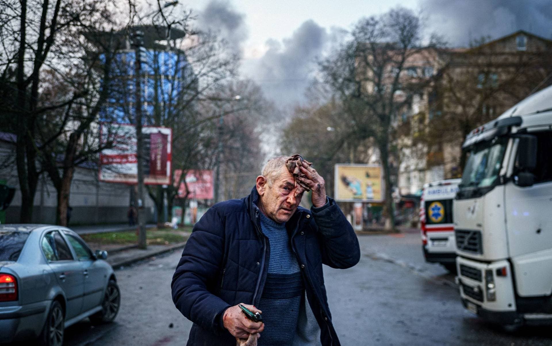 An injured man stands on a street after Russian shelling to Ukrainian city of Kherson