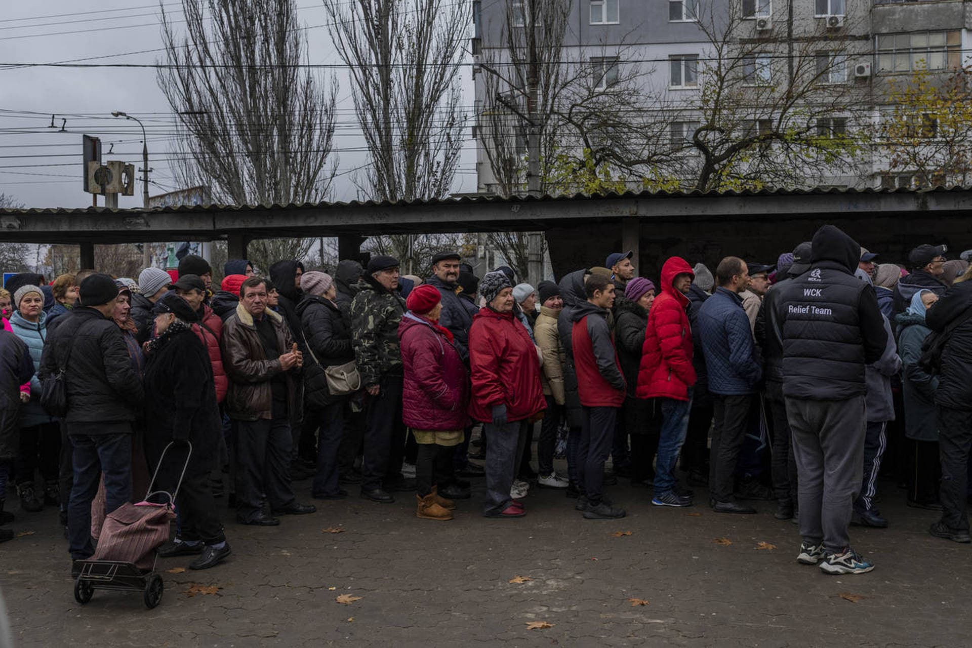 People queue to receive food donations in Kherson