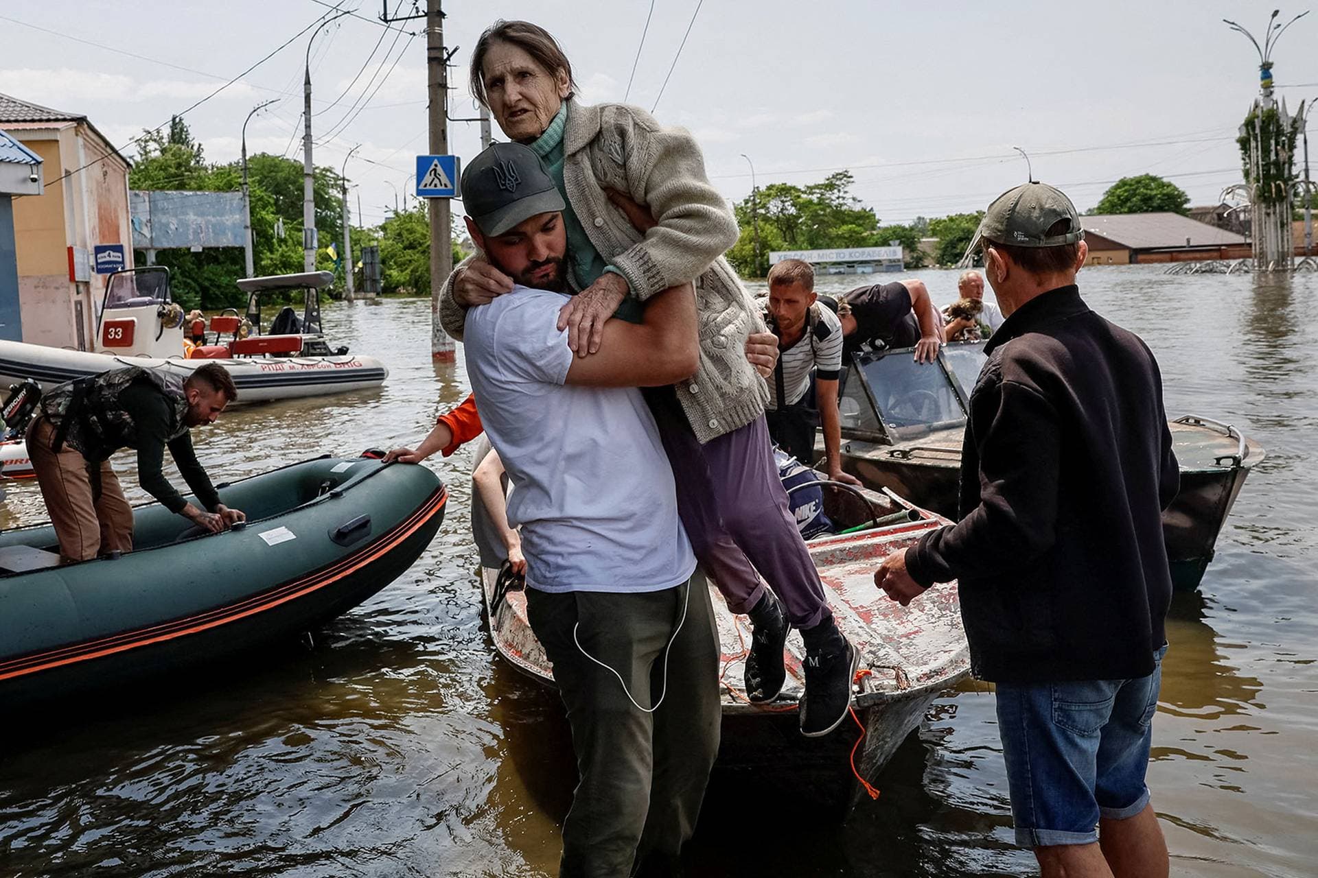 Volunteers evacuate local residents from a flooded area in Kherson