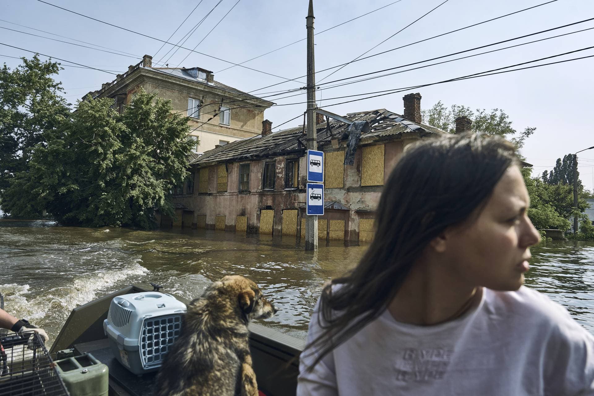 A Local resident with her pets evacuate on a boat from a flooded neighbourhood in Kherson