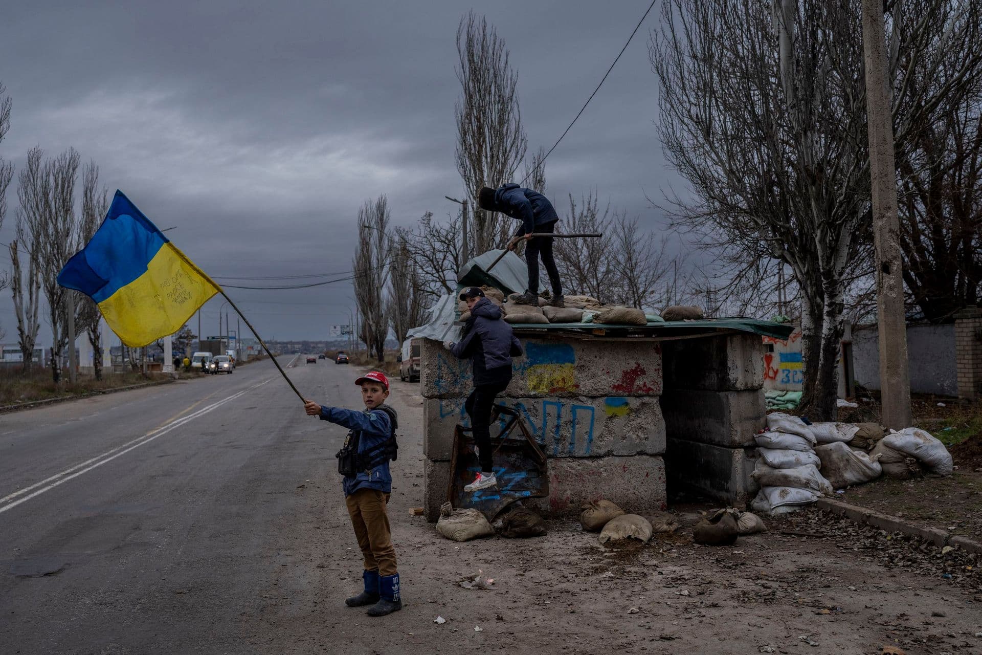 Ukrainian children play at an abandoned checkpoint in Kherson