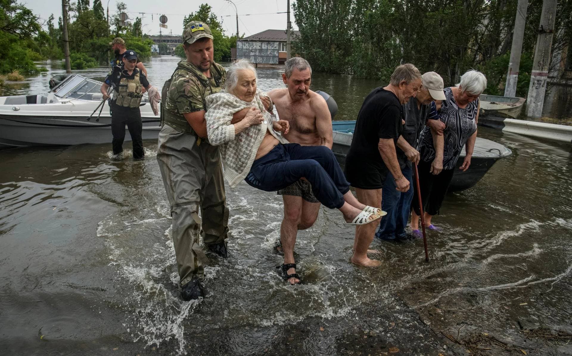 Rescuers evacuate local residents from a flooded area after the Nova Kakhovka dam breached