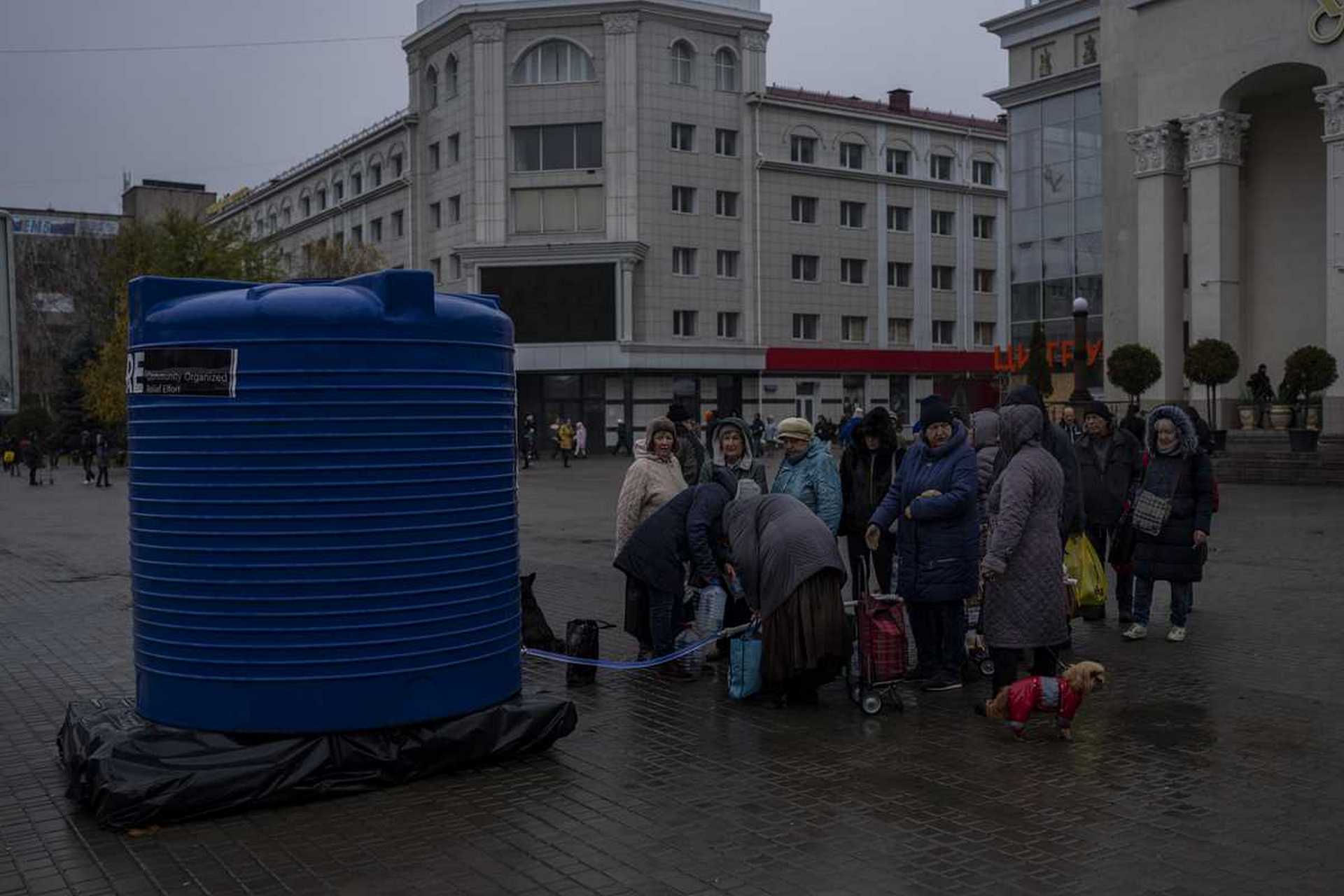 Residents queue to fill containers with drinking water delivered by World Central Kitchen in Kherson