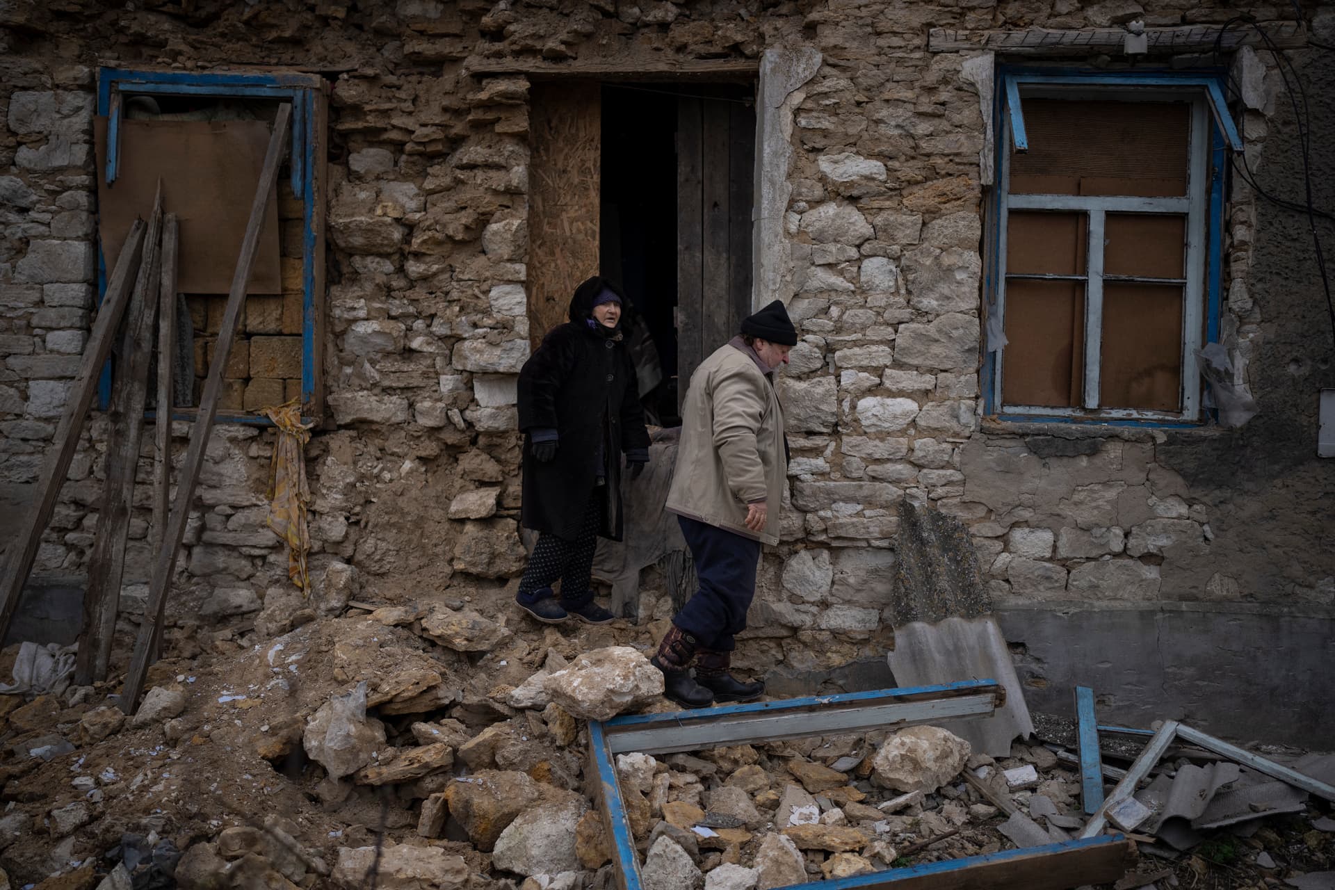 Oleksandra Hryhoryna, left, inspects her house which was damaged by shelling last fall in Kalynivske