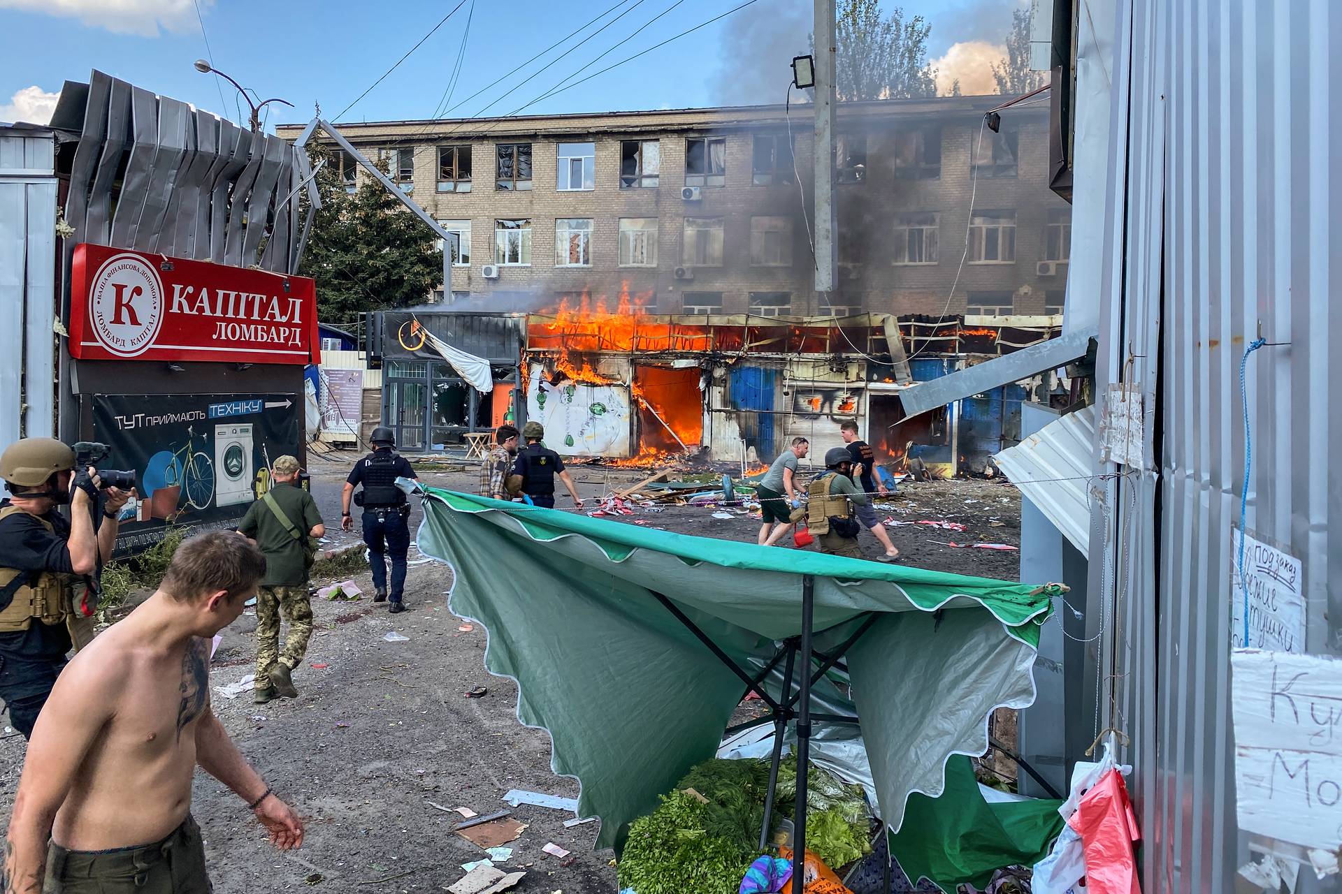 Firefighters extinguish a blaze that broke out in the market in Kostiantynivka after the missile strike