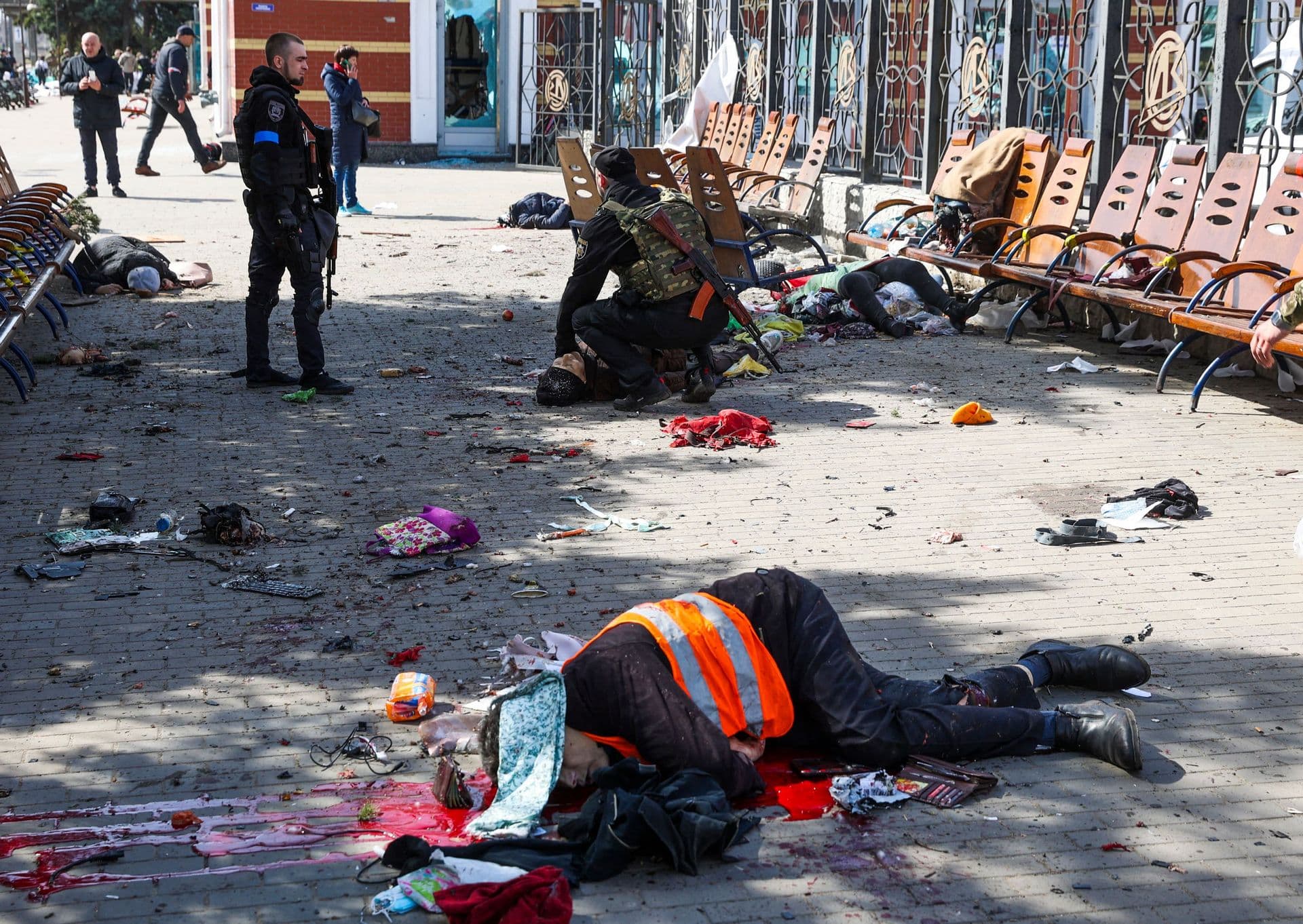 Ukrainian service men check for signs of life among casualties lying on the platform in the aftermath of a rocket attack on the railway station in Kramatorsk