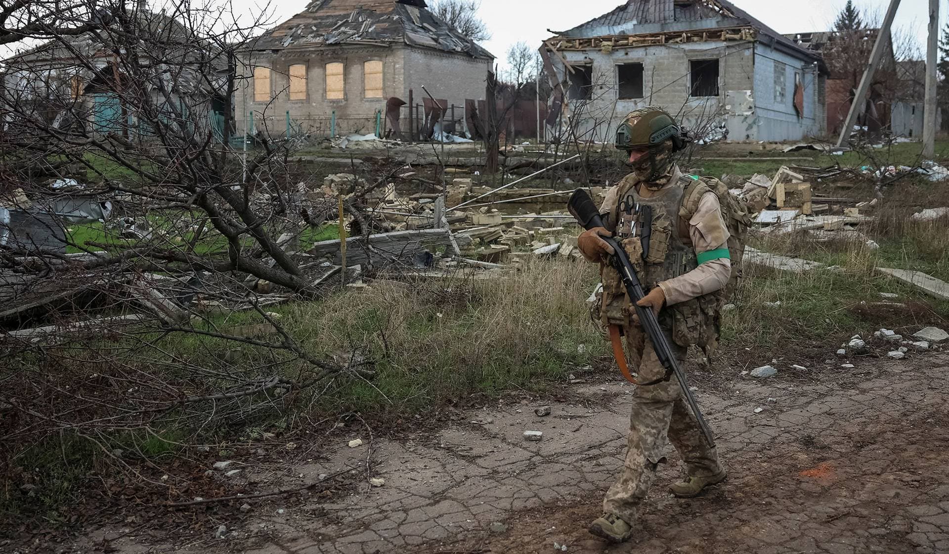 A serviceman of the Armed Forces of Ukraine walks near buildings damaged by Russian military strike in the frontline town of Kostiantynivka