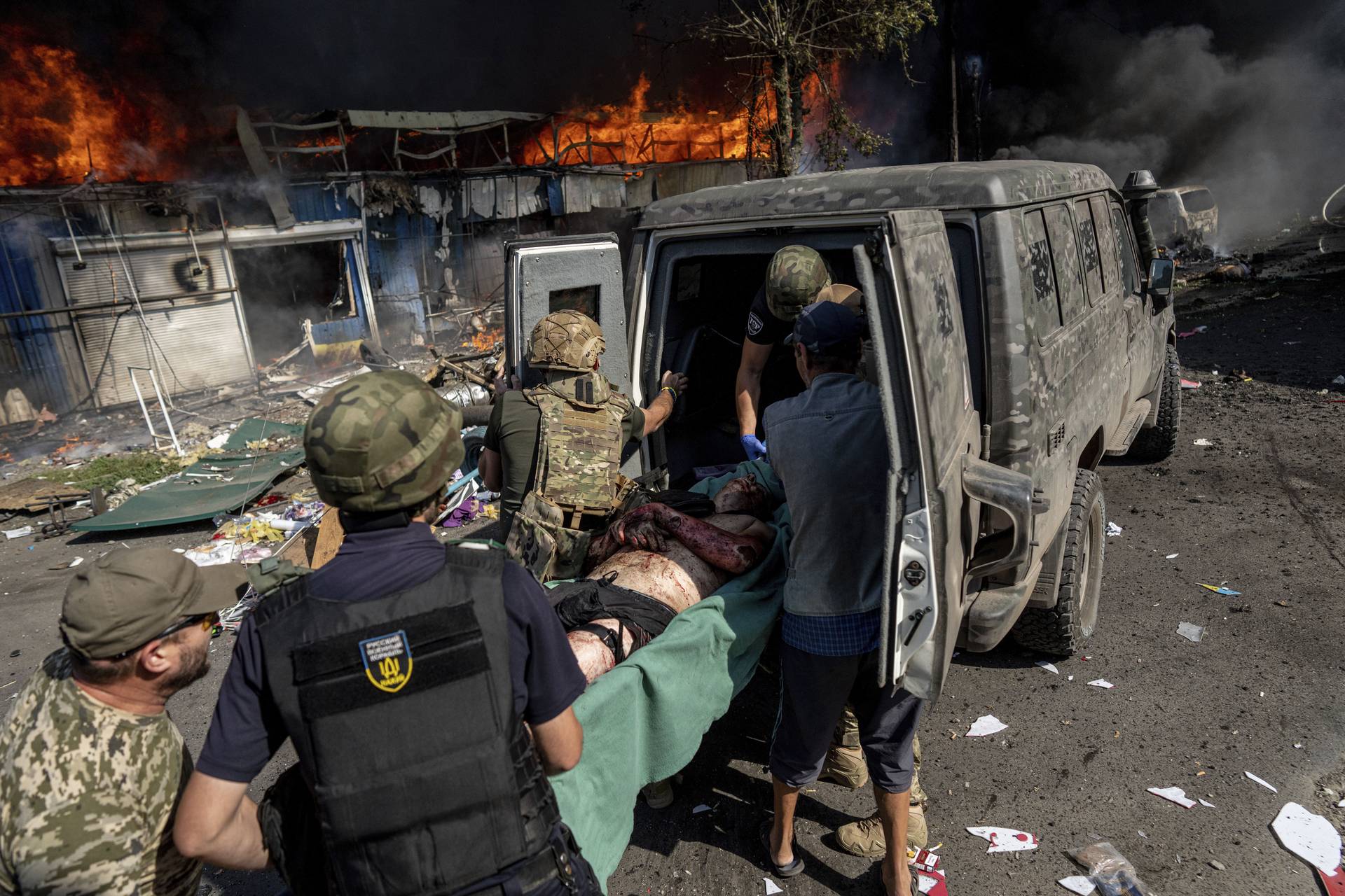 Paramedics carry an injured man into an ambulance after a Russian rocket attack in the city of Kostiantynivka