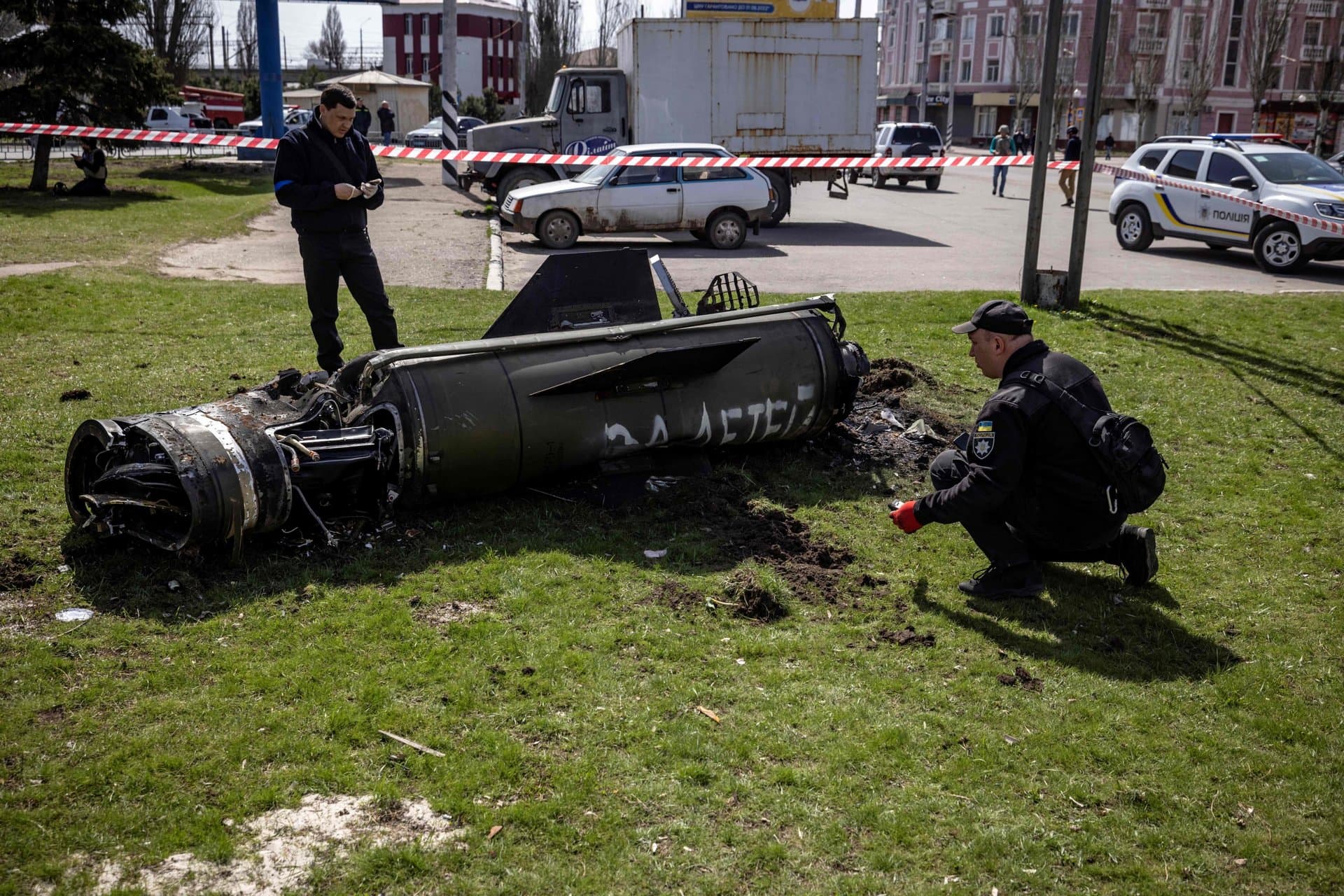 Ukrainian police inspect the remains of a large rocket next to the main building of a train station in Kramatorsk