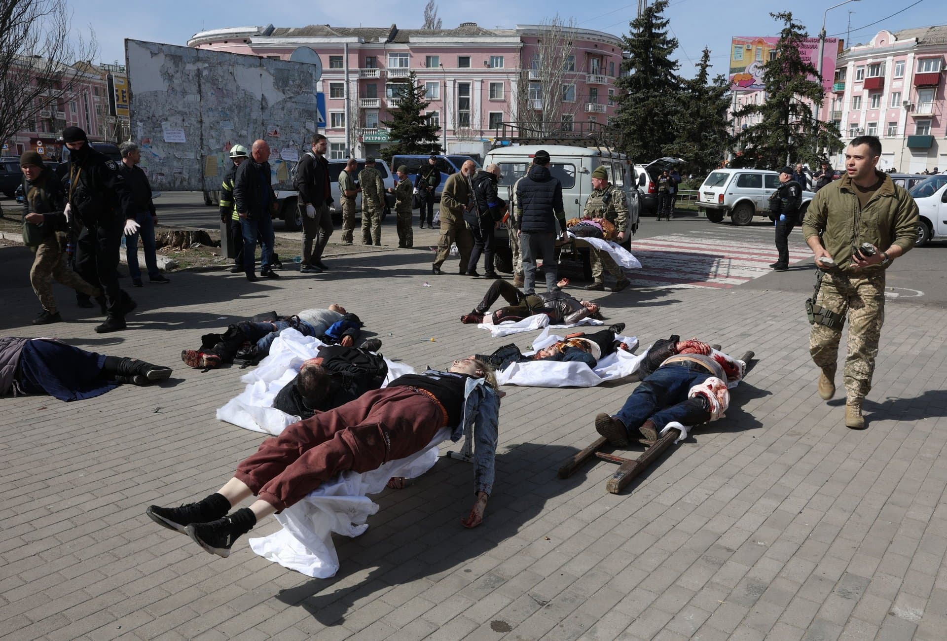 Ukrainian servicemen and emergency personnel tend to victims in the aftermath of a rocket attack on the railway station in Kramatorsk