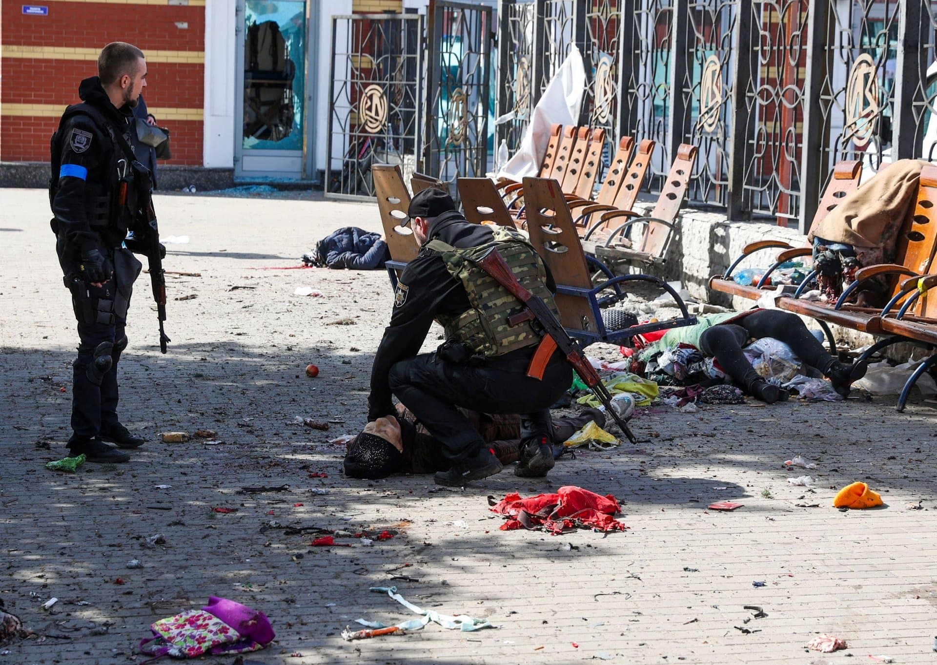 Ukrainian servicemen check for signs of life among casualties lying on the platform in the aftermath of a rocket attack on the railway station in the eastern city of Kramatorsk