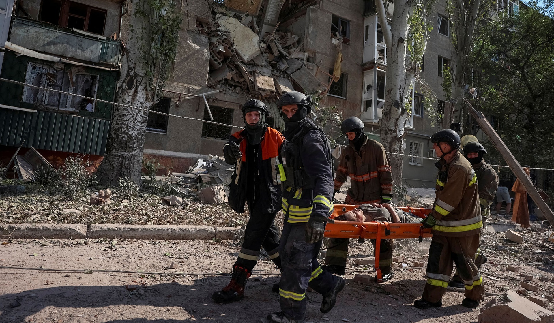 Rescuers carry the person found under debris of an apartment building damaged during a Russian air strike in the frontline city of Kramatorsk