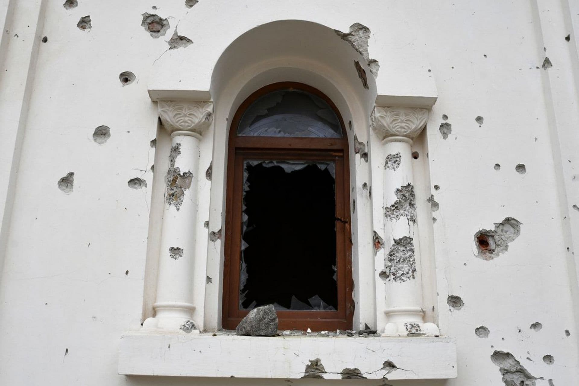 Shrapnel holes around a broken window of the St. George's Skete in the village of Dolyna
