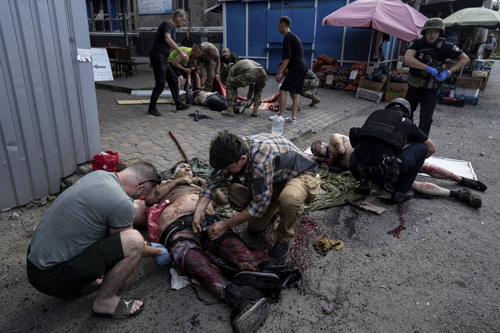 Paramedics give first aid to injured people at the food market after a Russian shelling attack in the city center of Kostiantynivka