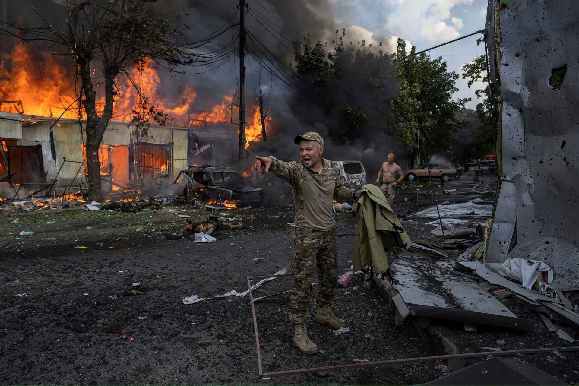 A Ukrainian serviceman shouts to paramedics on a busy market in the center of Kostyantynivka