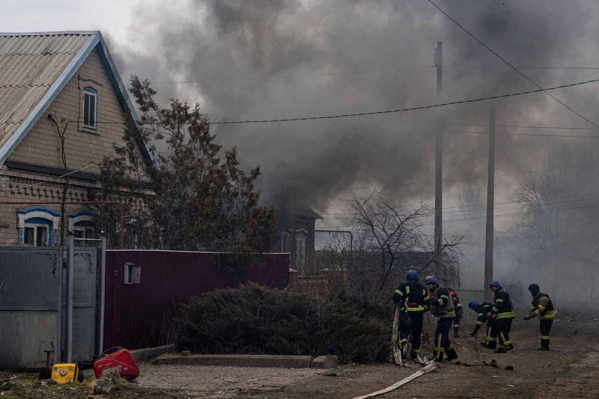 Rescue workers connect fire hoses to start extinguishing the fire after shelling by Russian forces of residential neighborhood in Kostiantynivka