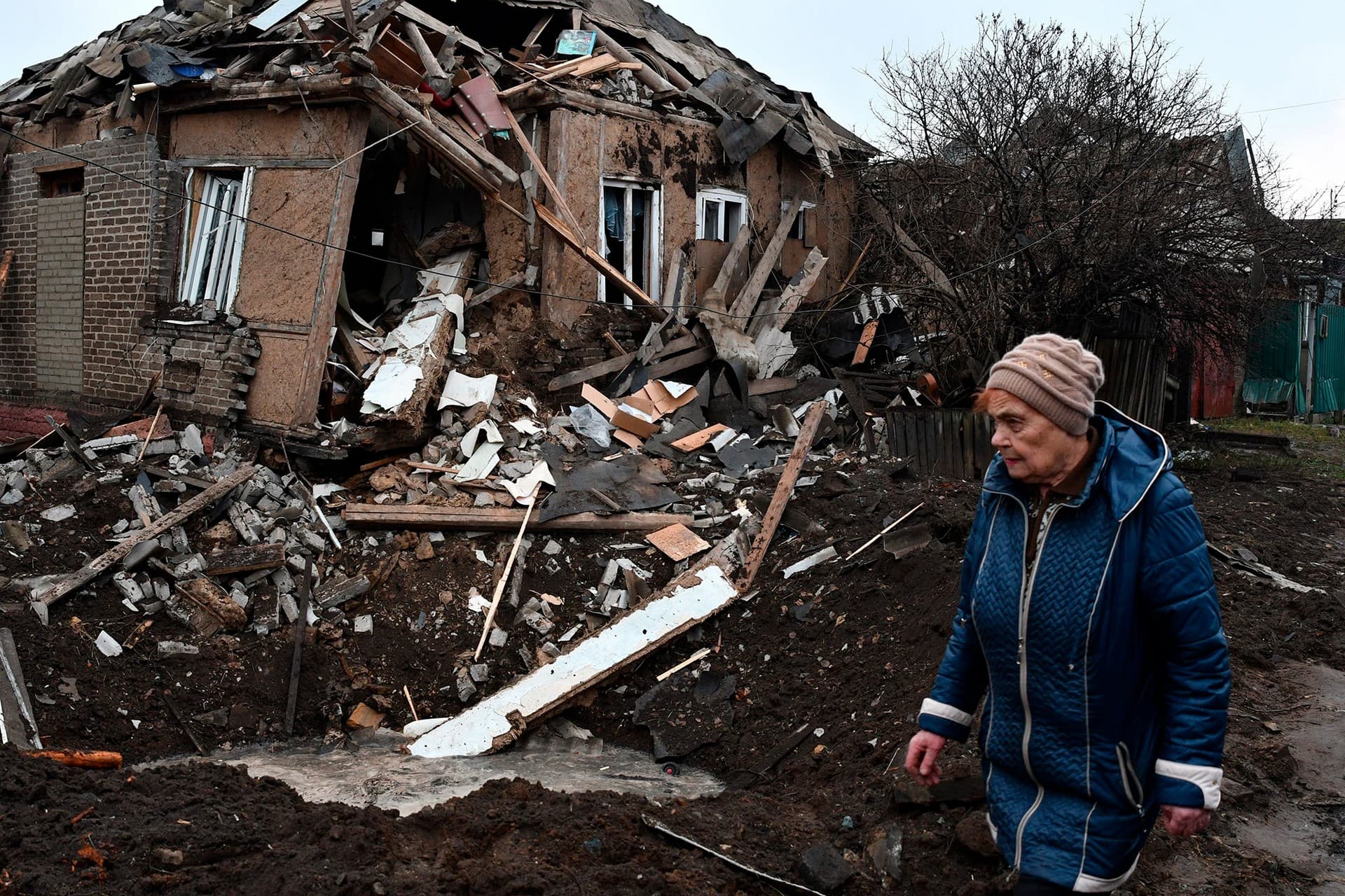 A woman walks past her house that was damaged in Russian shelling in Kramatorsk
