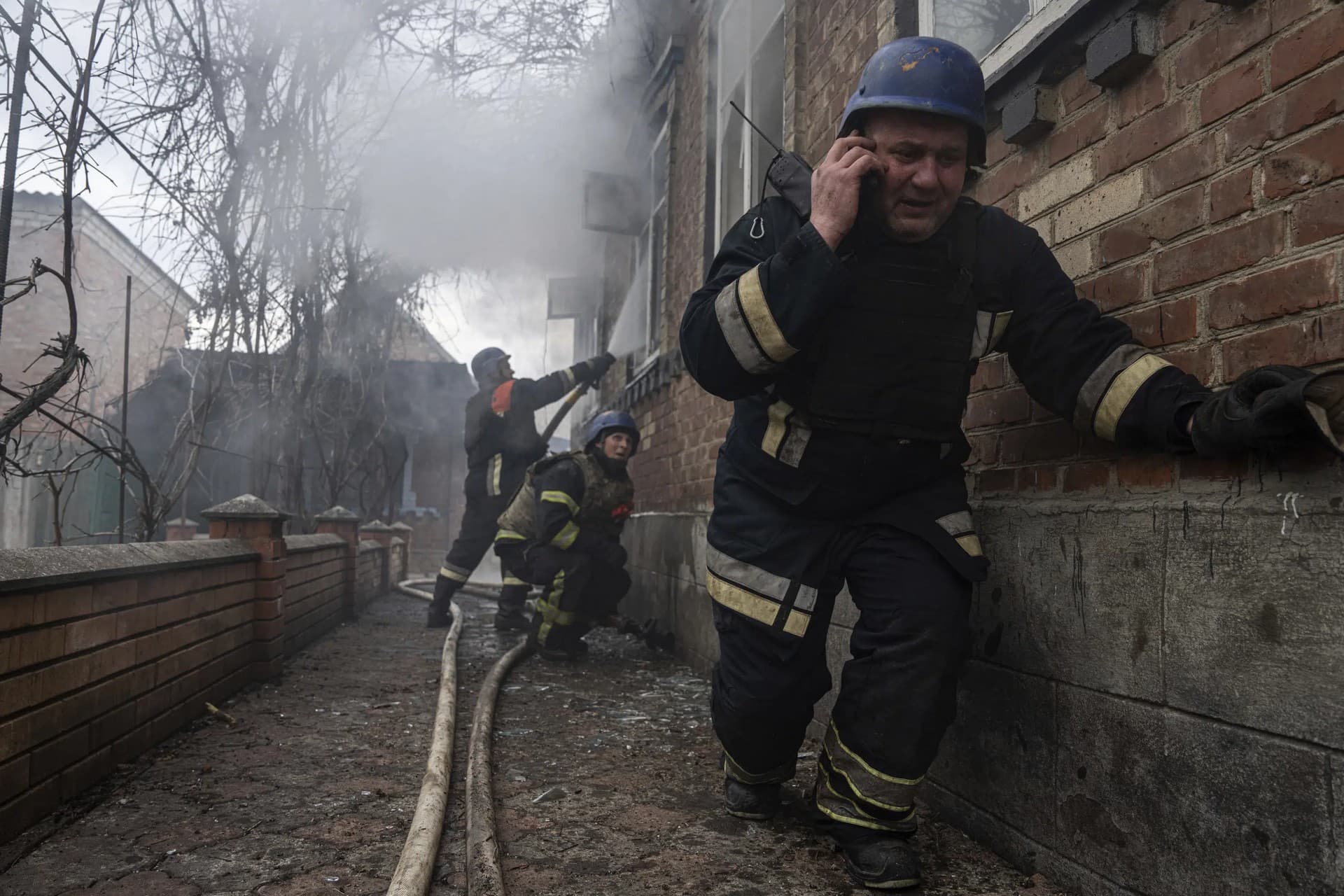A rescue worker speaks on the phone while his team puts out a fire in a house which was shelled by Russian forces at the residential neighbourhood in Kostiantynivka