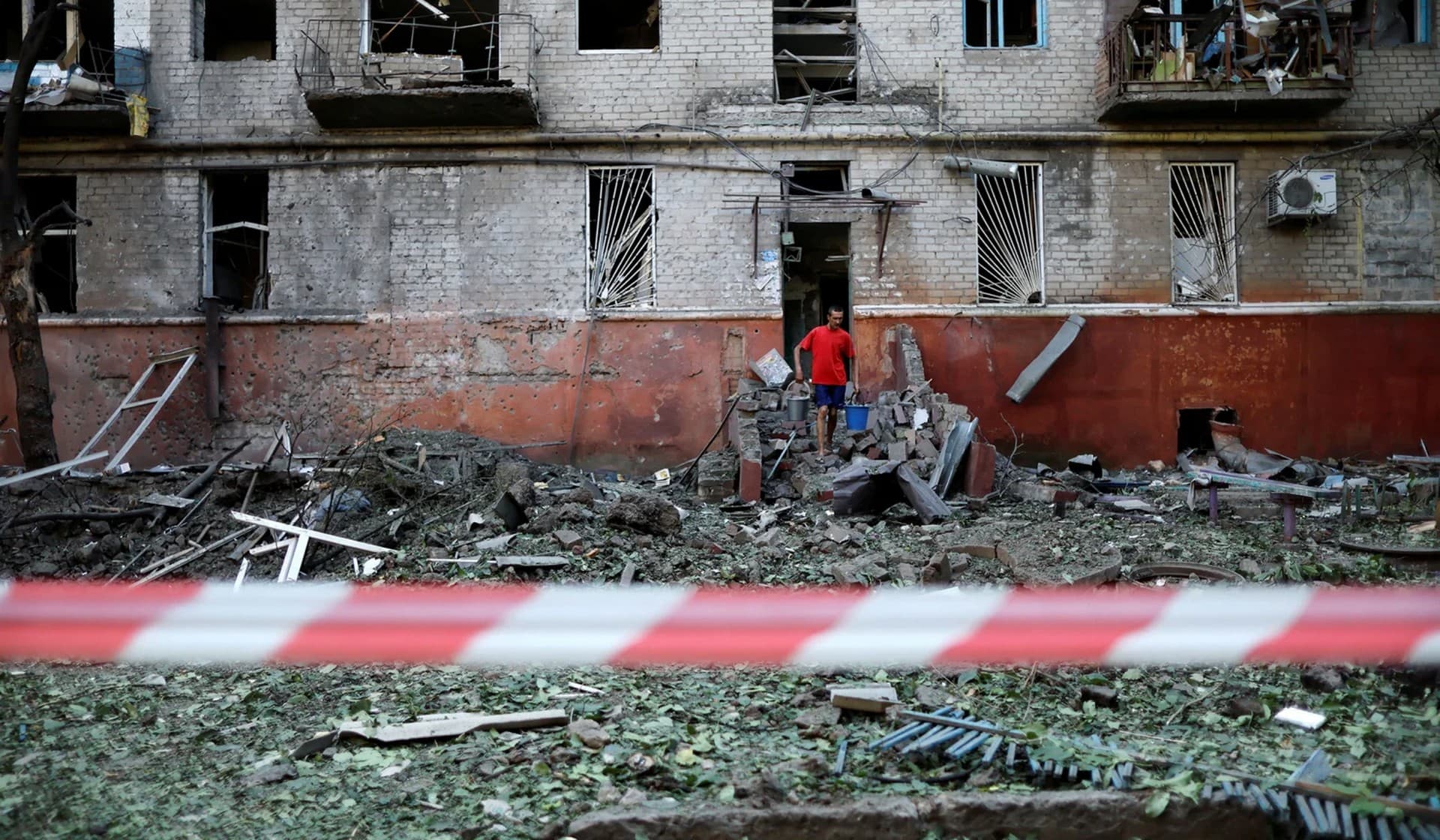 A Ukrainian man walks out a residential building damaged after a Russian strike, as Russia's attack on Ukraine continues, in Kramatorsk